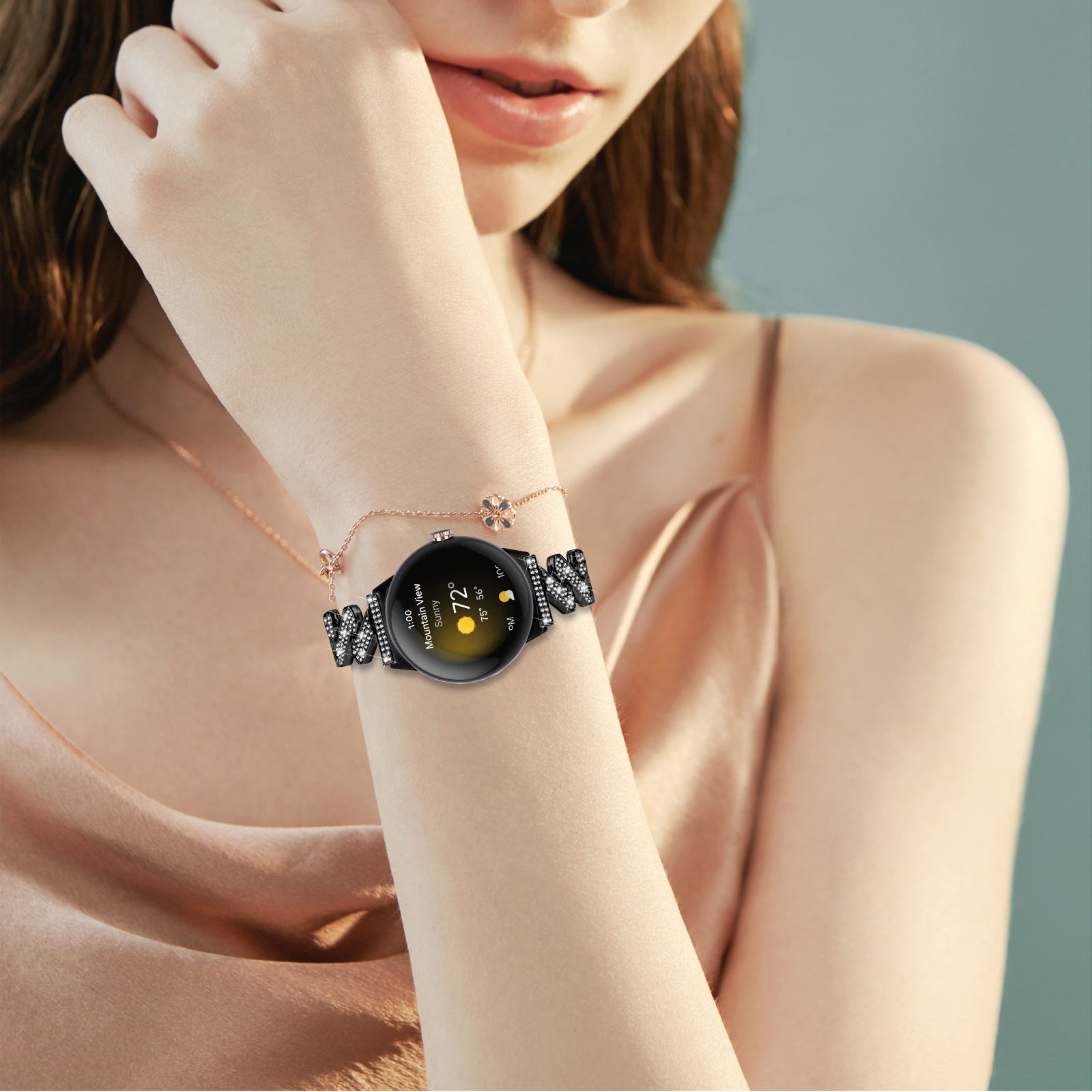 Una donna indossa uno smartwatch con cinturino nero adornato di scintillii.