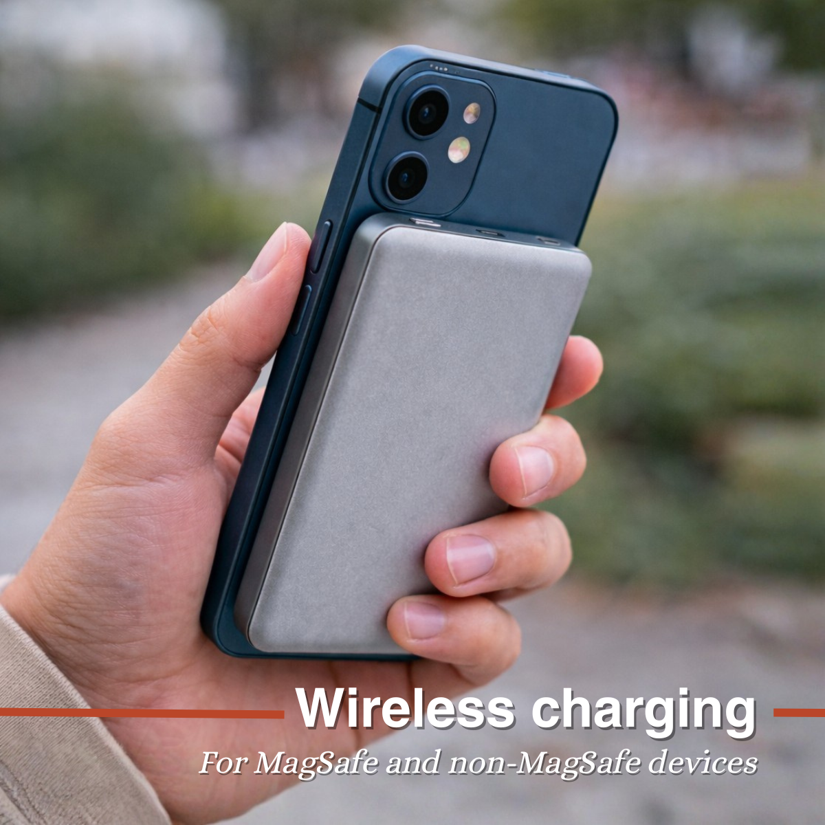 Hand holding a blue iPhone with a silver charging pack attached.