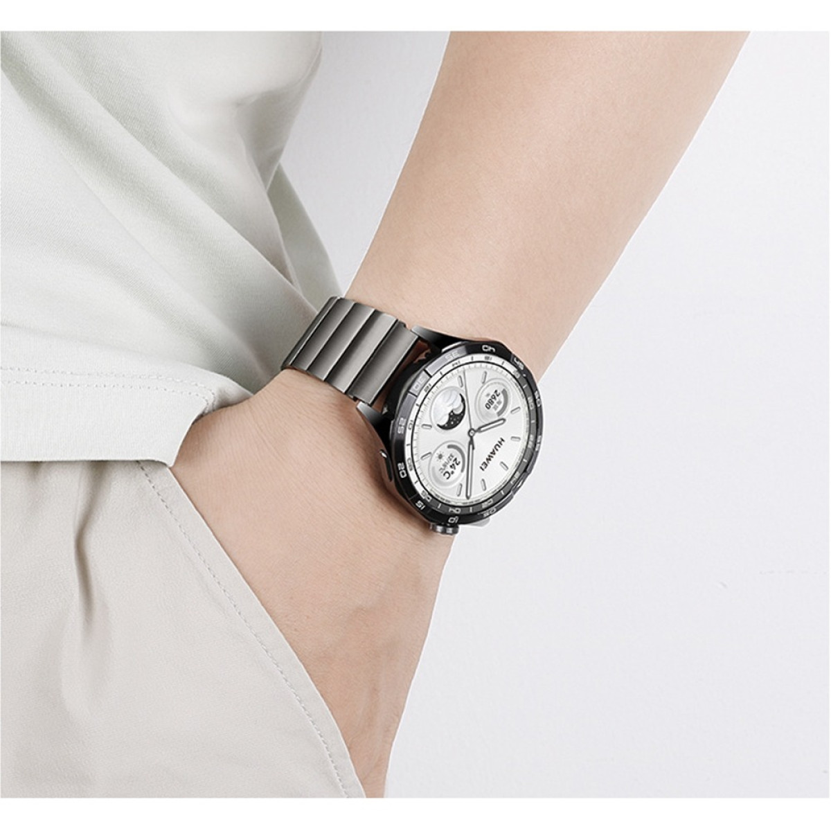 Primo piano di un polso con uno smartwatch con cinturino argentato e quadrante bianco.