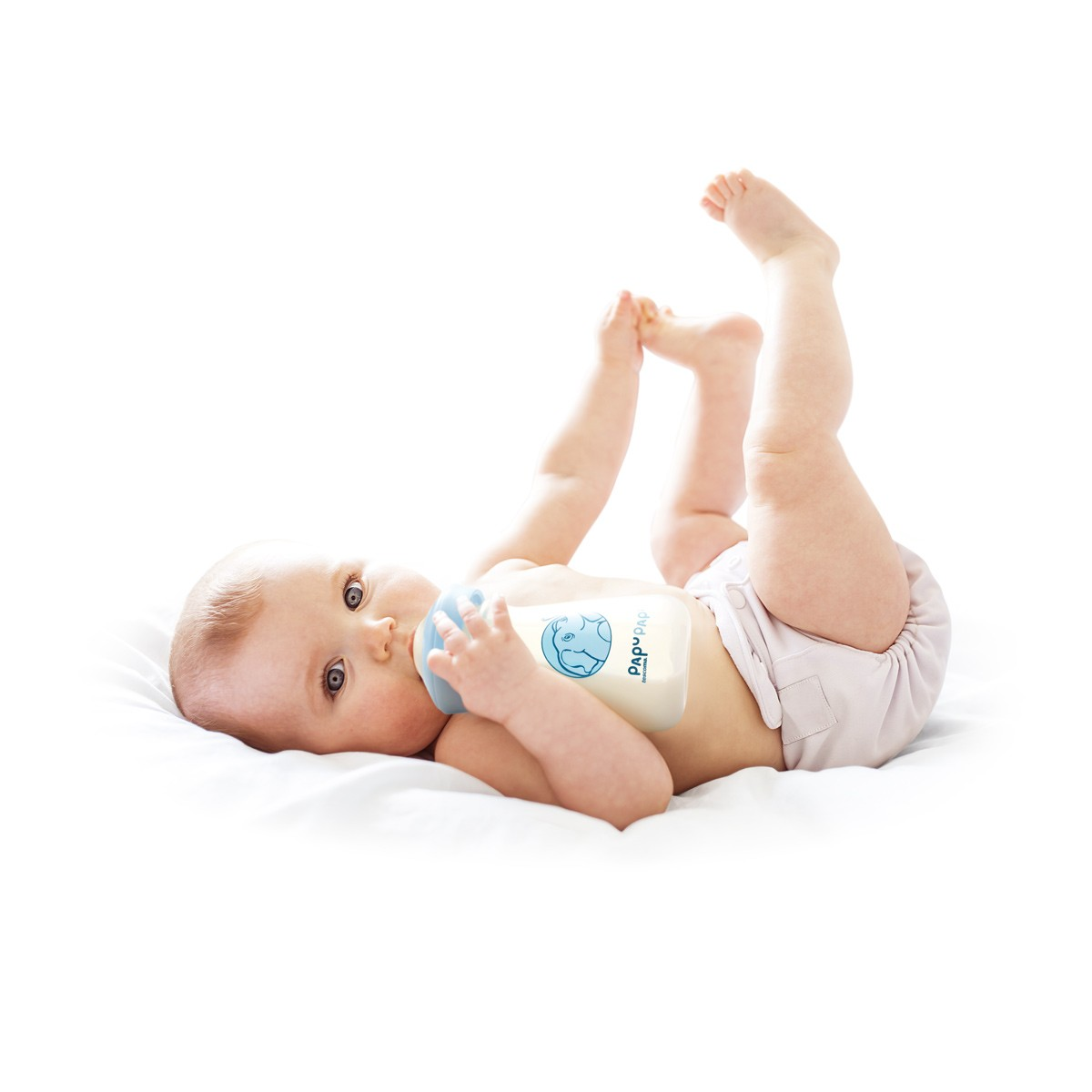 Ein Baby liegt auf dem Rücken und trinkt aus einer Flasche.