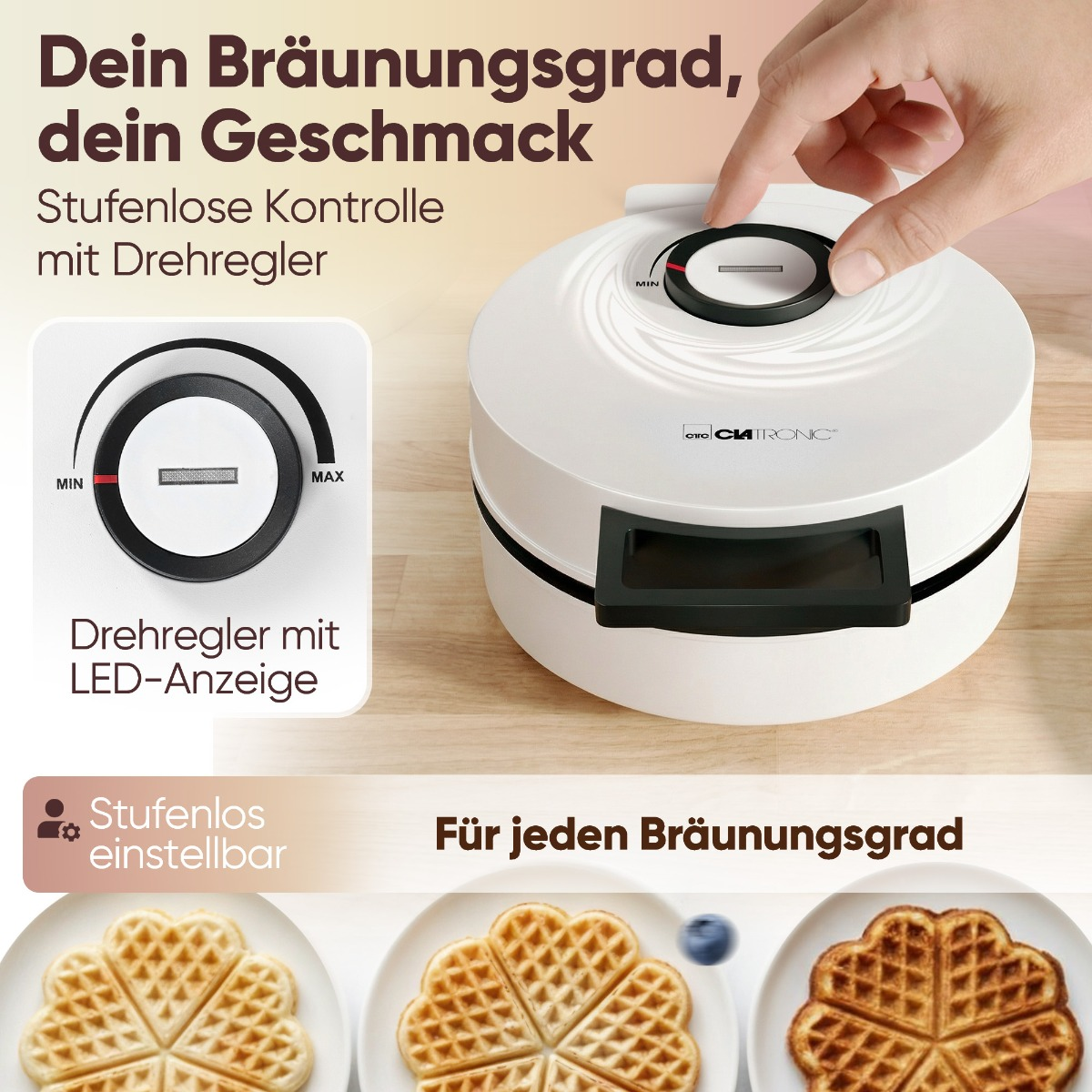 Ein weißer Waffelautomat mit Drehregler und LED-Anzeige, daneben Herz-Waffeln.