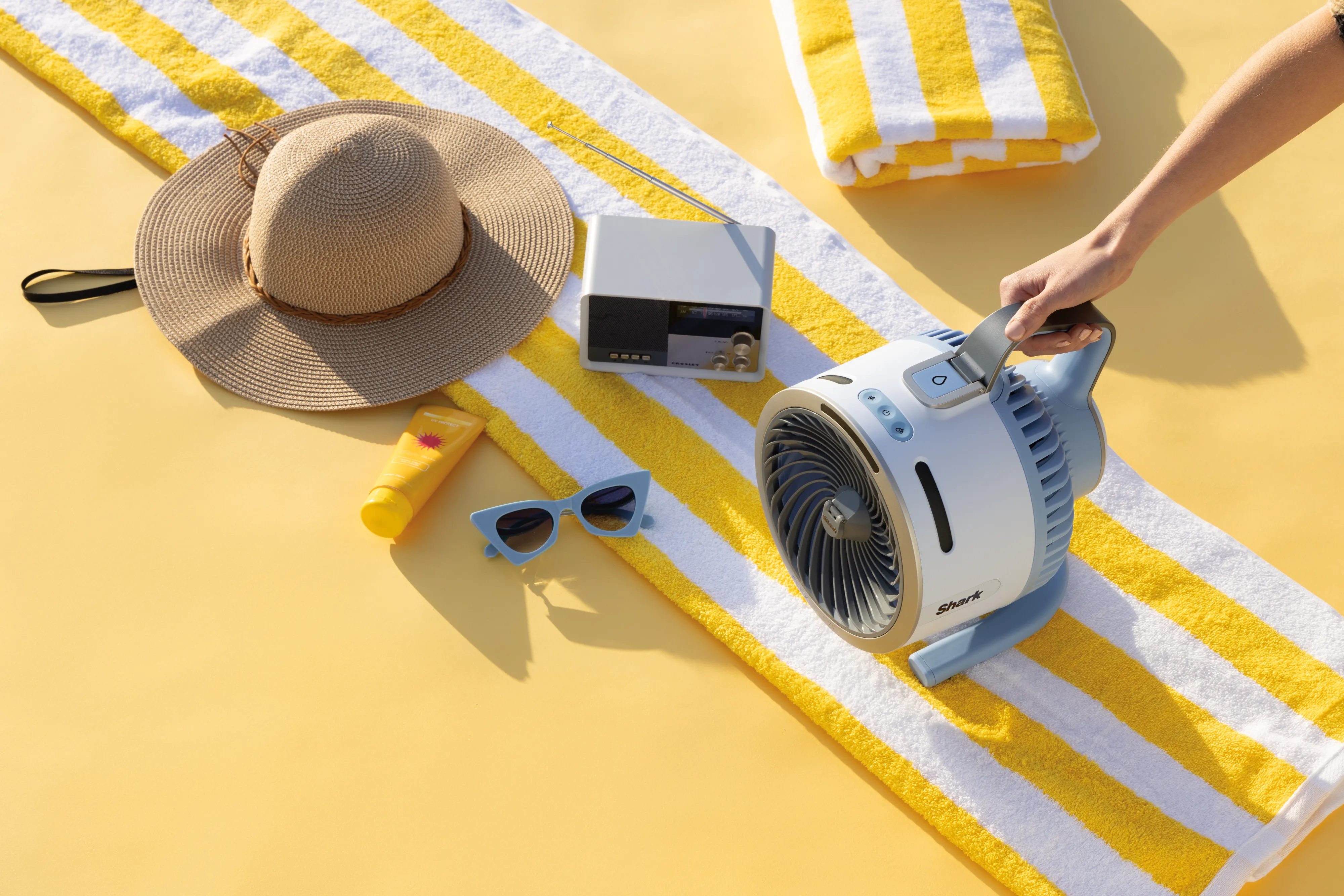 Set da spiaggia: cappello, crema solare, occhiali da sole, radio, ventilatore, asciugamano.