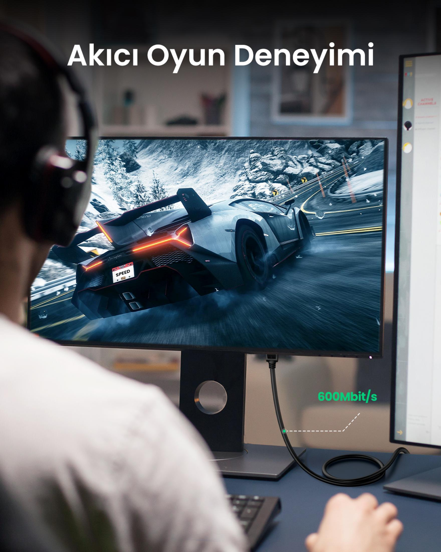 Osoba gra w grę wyścigową na monitorze, kabel pokazuje 600Mbit/s.