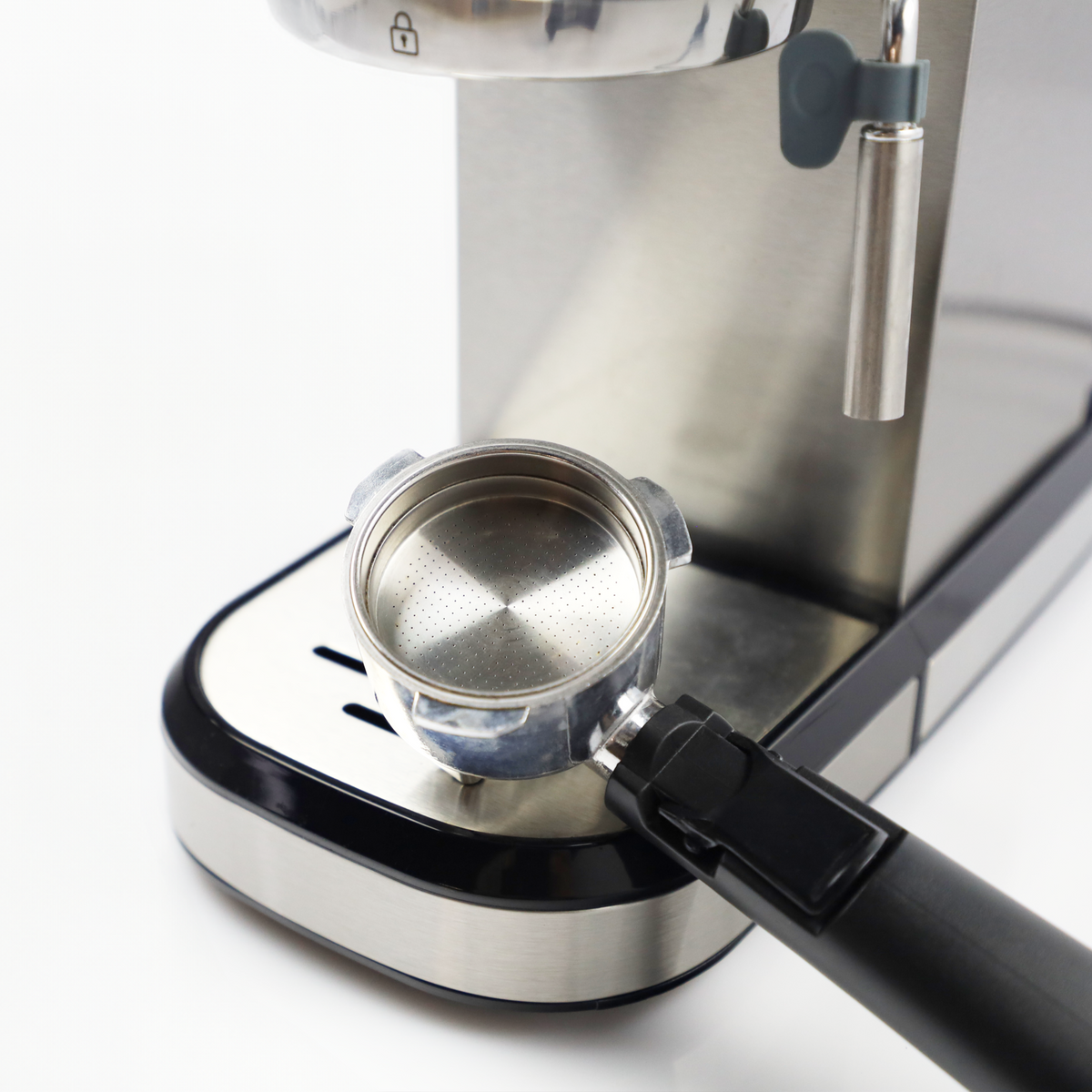 Srebrny uchwyt filtra z czarną rączką na ekspresie do kawy.