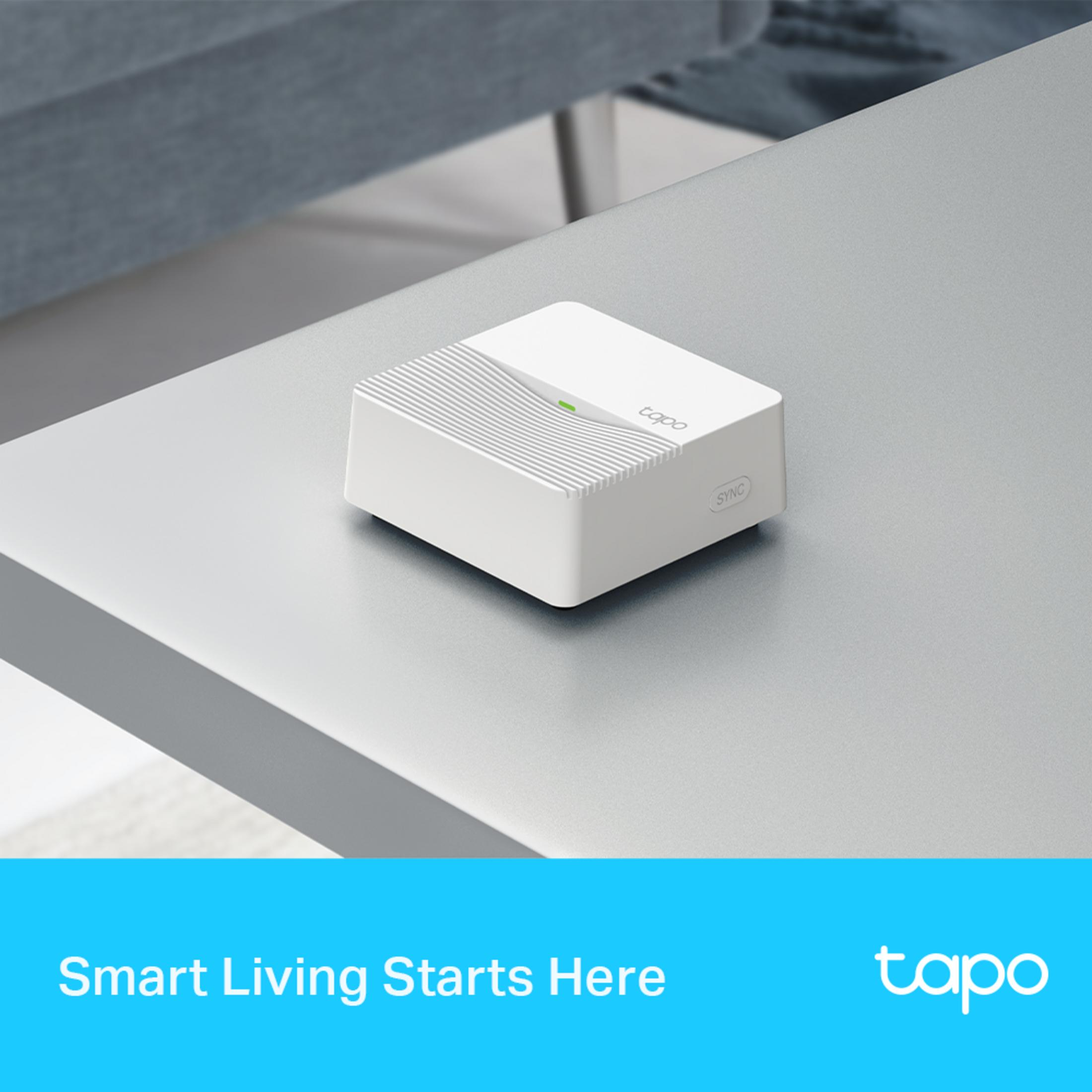 Un appareil domotique blanc Tapo avec une LED verte sur une table.