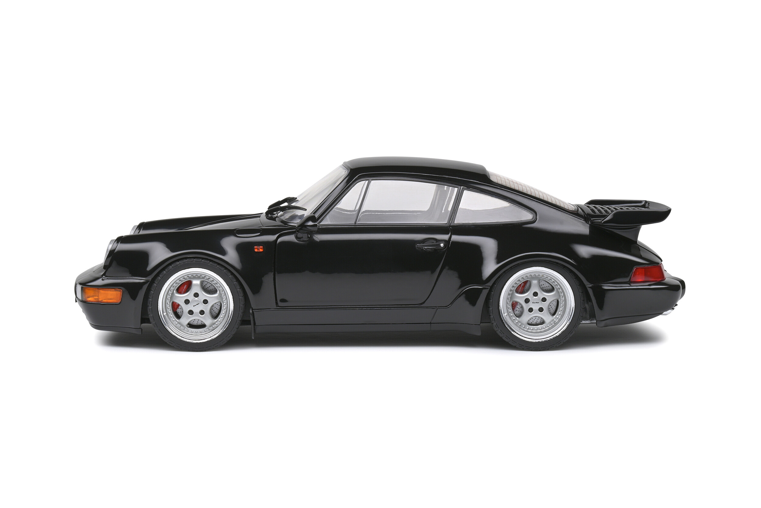 Schwarzer Porsche 911 Turbo mit silbernen Felgen und roten Bremssätteln.