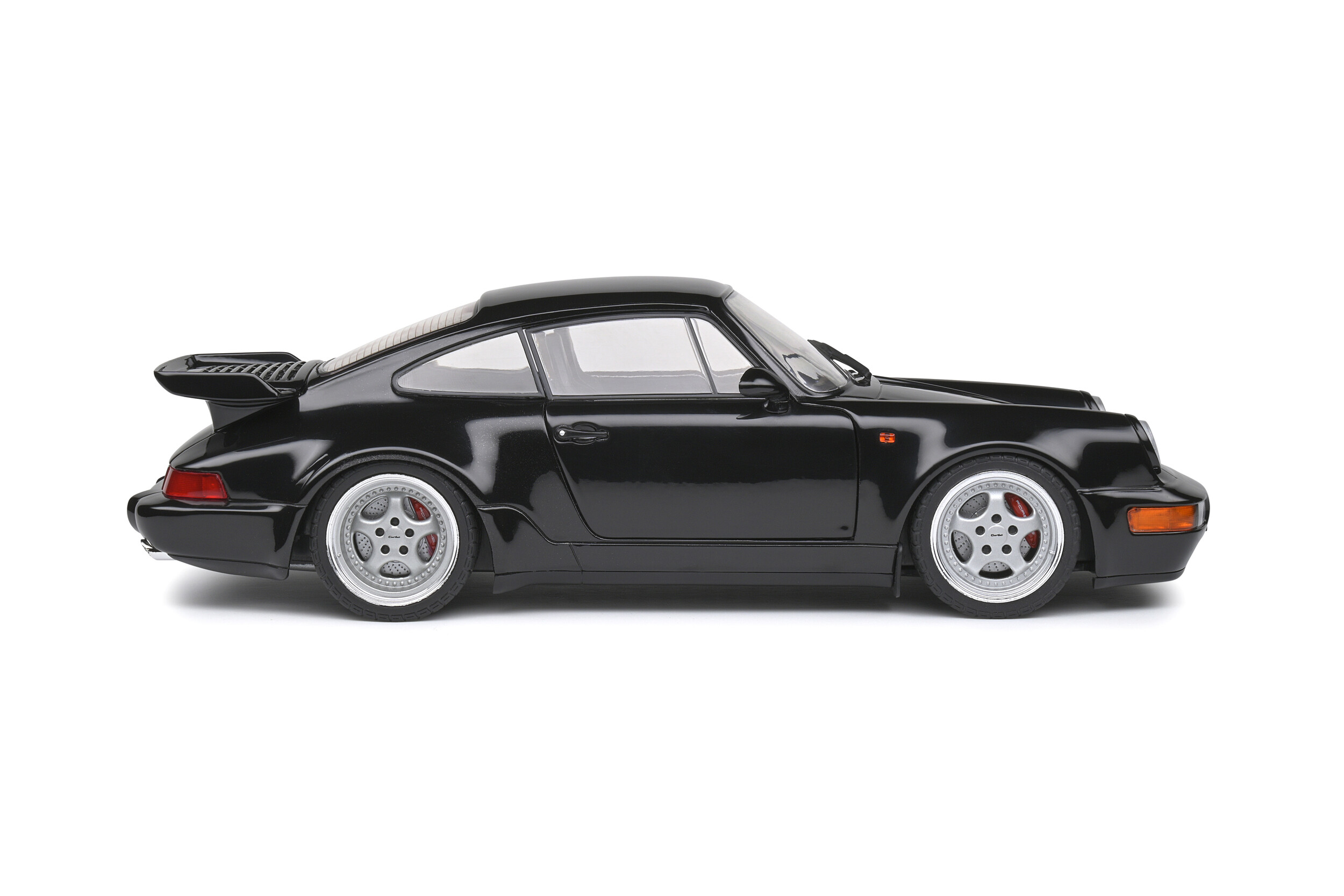 Schwarzer Porsche 911 Turbo mit silbernen Felgen und roten Bremssätteln.