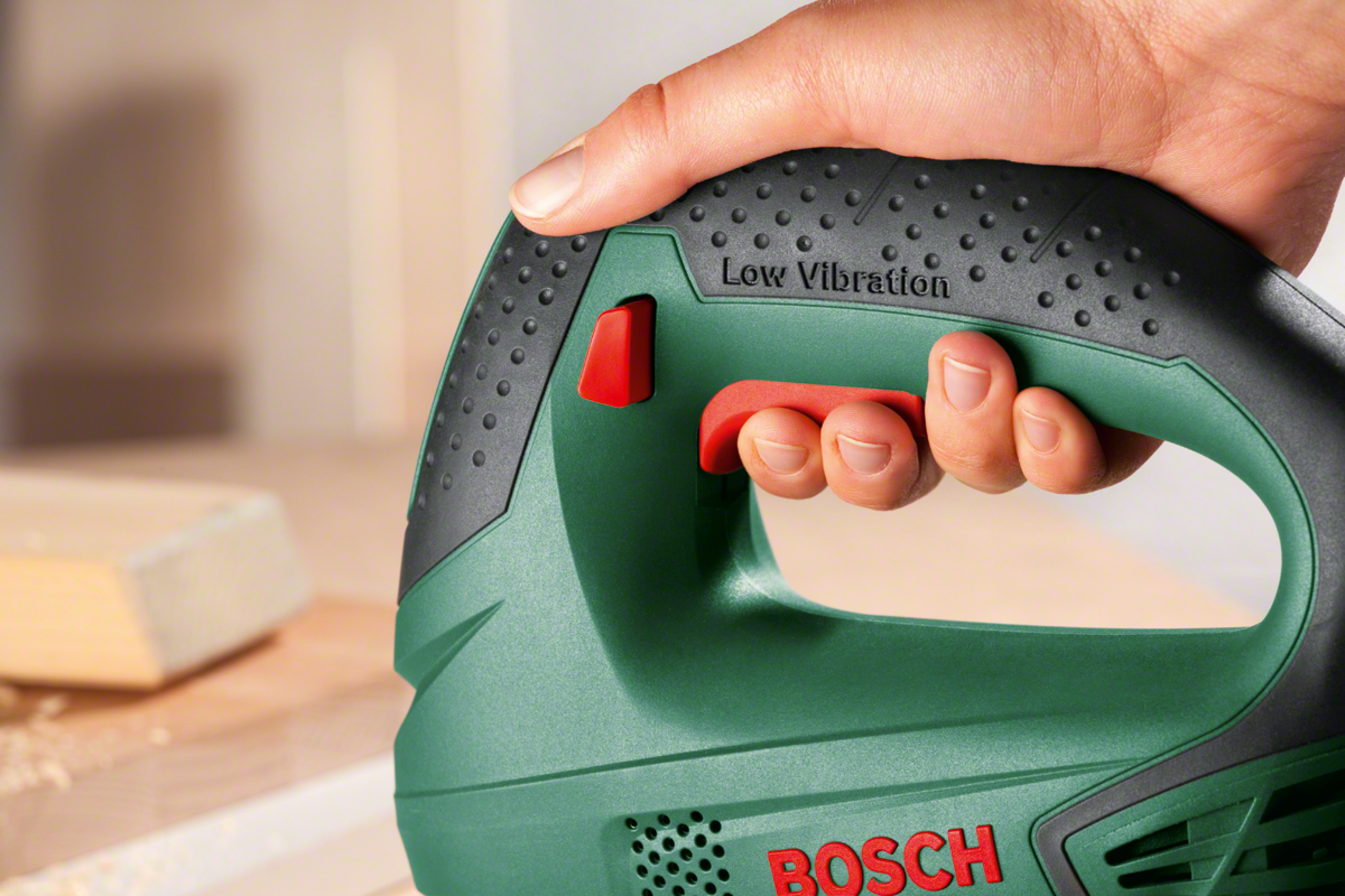 Groen Bosch decoupeerzaag handvat met rode knop. Tekst "Low Vibration".