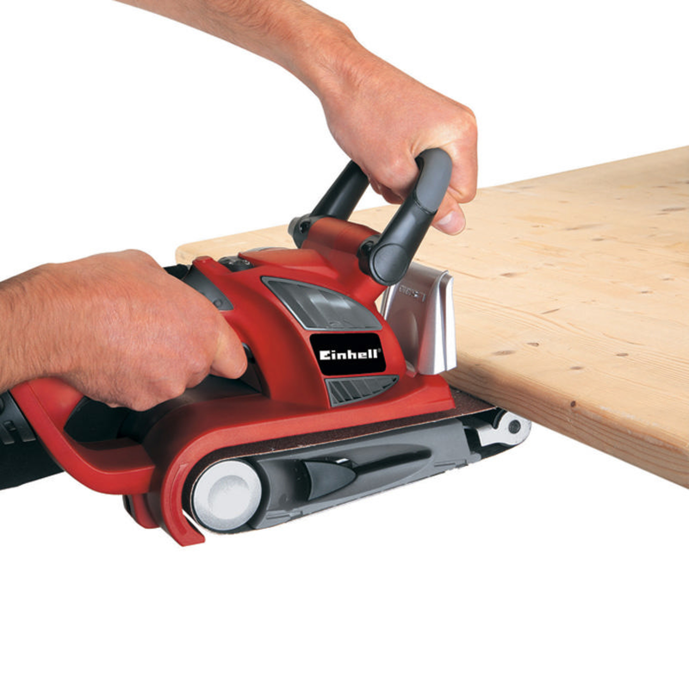 Un uomo leviga una tavola di legno con una levigatrice a nastro rossa.