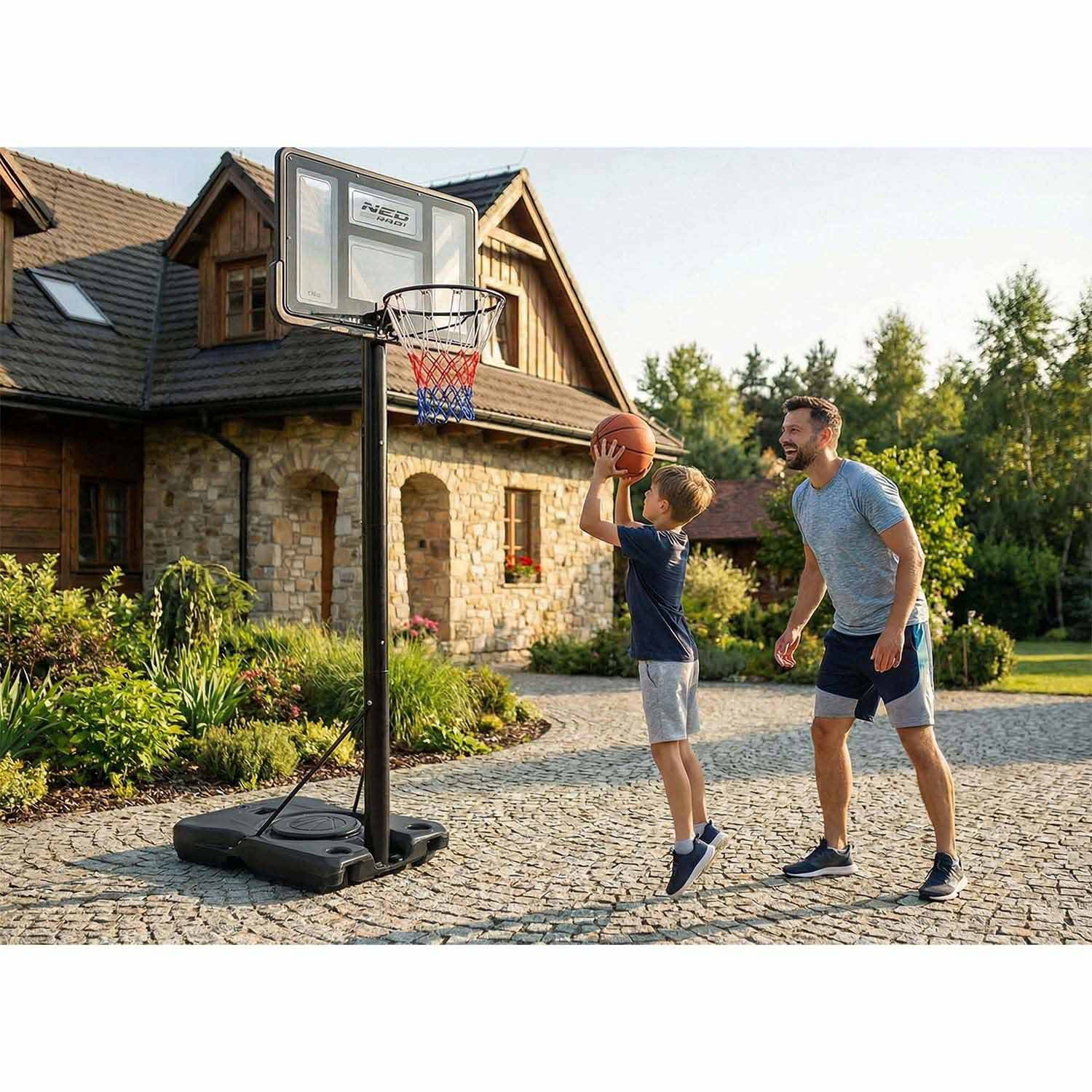 Mężczyzna i chłopiec grają w koszykówkę przed domem na zewnątrz.