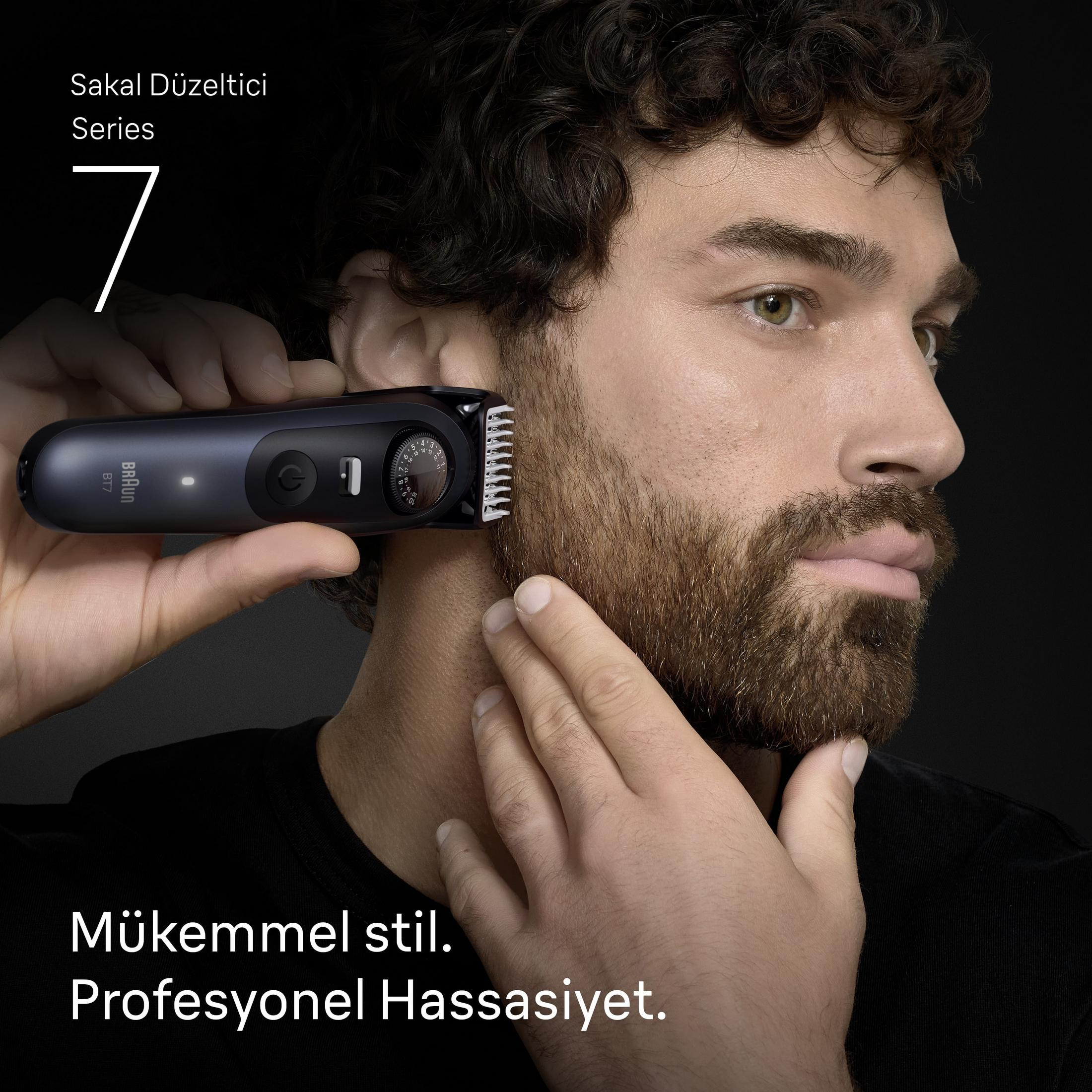 Uomo si taglia la barba con rifinitore Braun Serie 7. Sfondo nero.