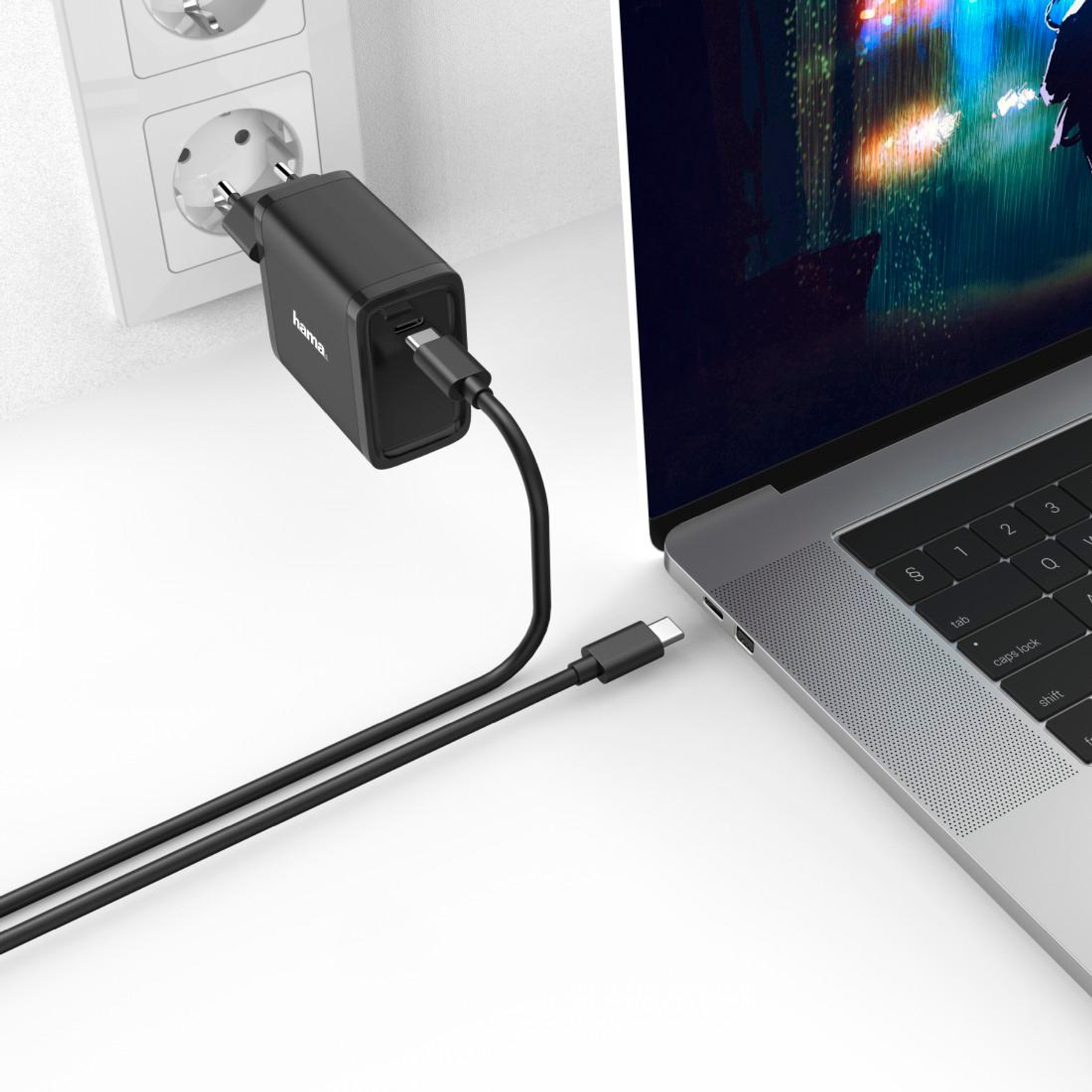 Schwarzes Hama-Ladegerät in Wandsteckdose, lädt Laptop per USB-C-Kabel.