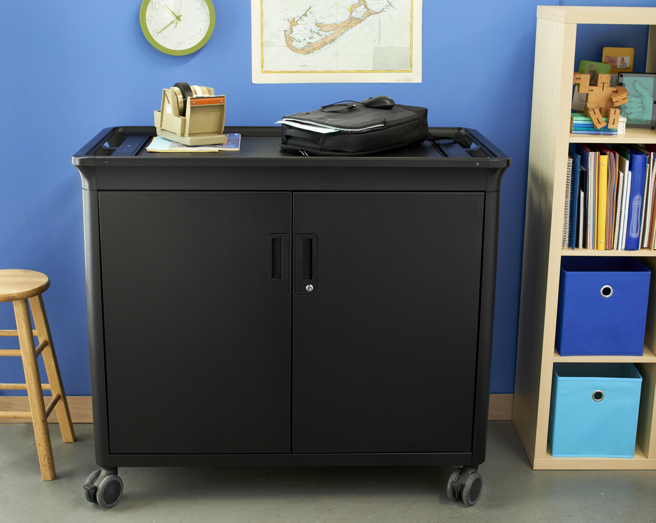 Czarna szafka na kółkach z przedmiotami na górze i półkami z pudełkami.
