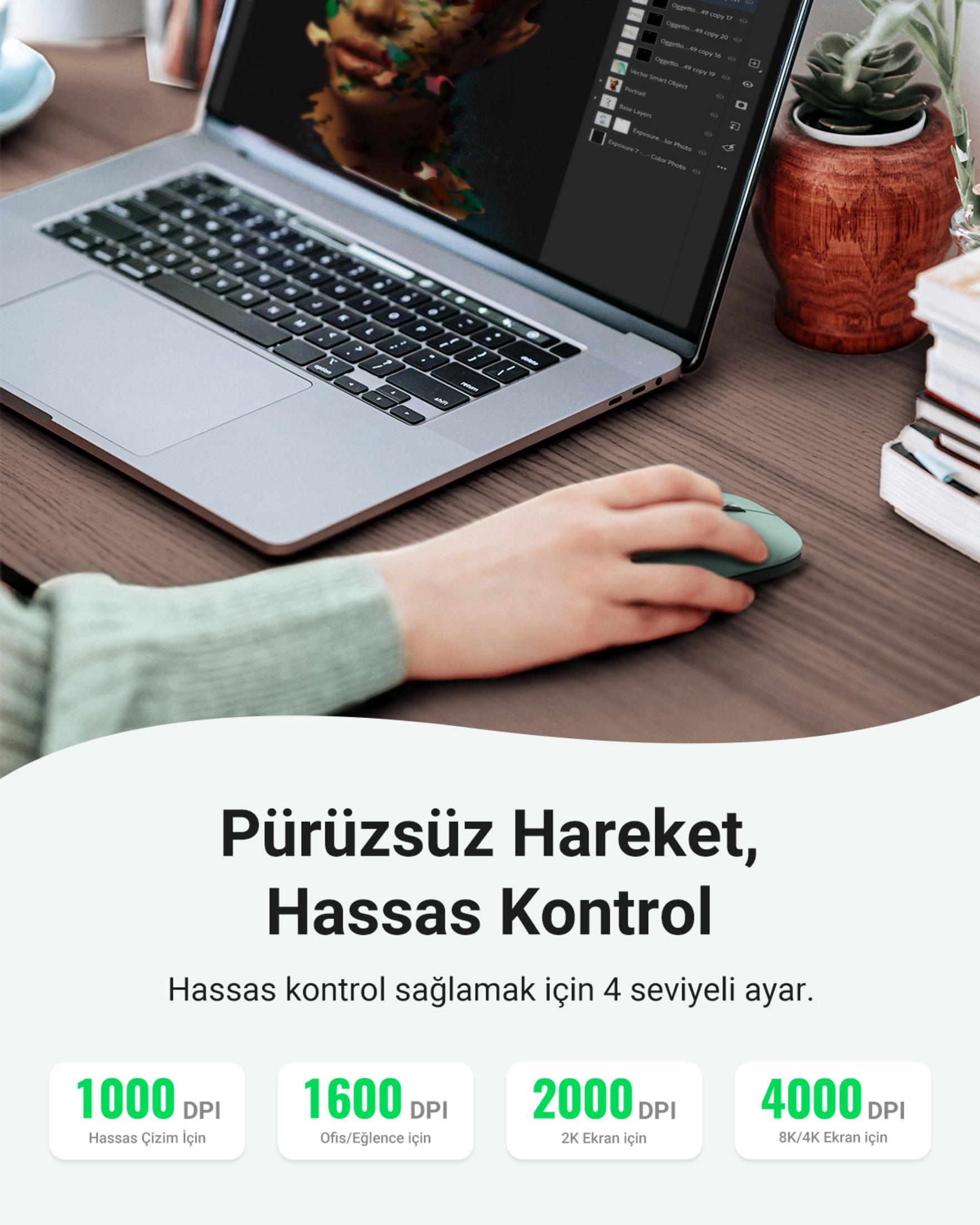 Eine Hand benutzt eine Maus vor einem Laptop, der Bildbearbeitungssoftware anzeigt.