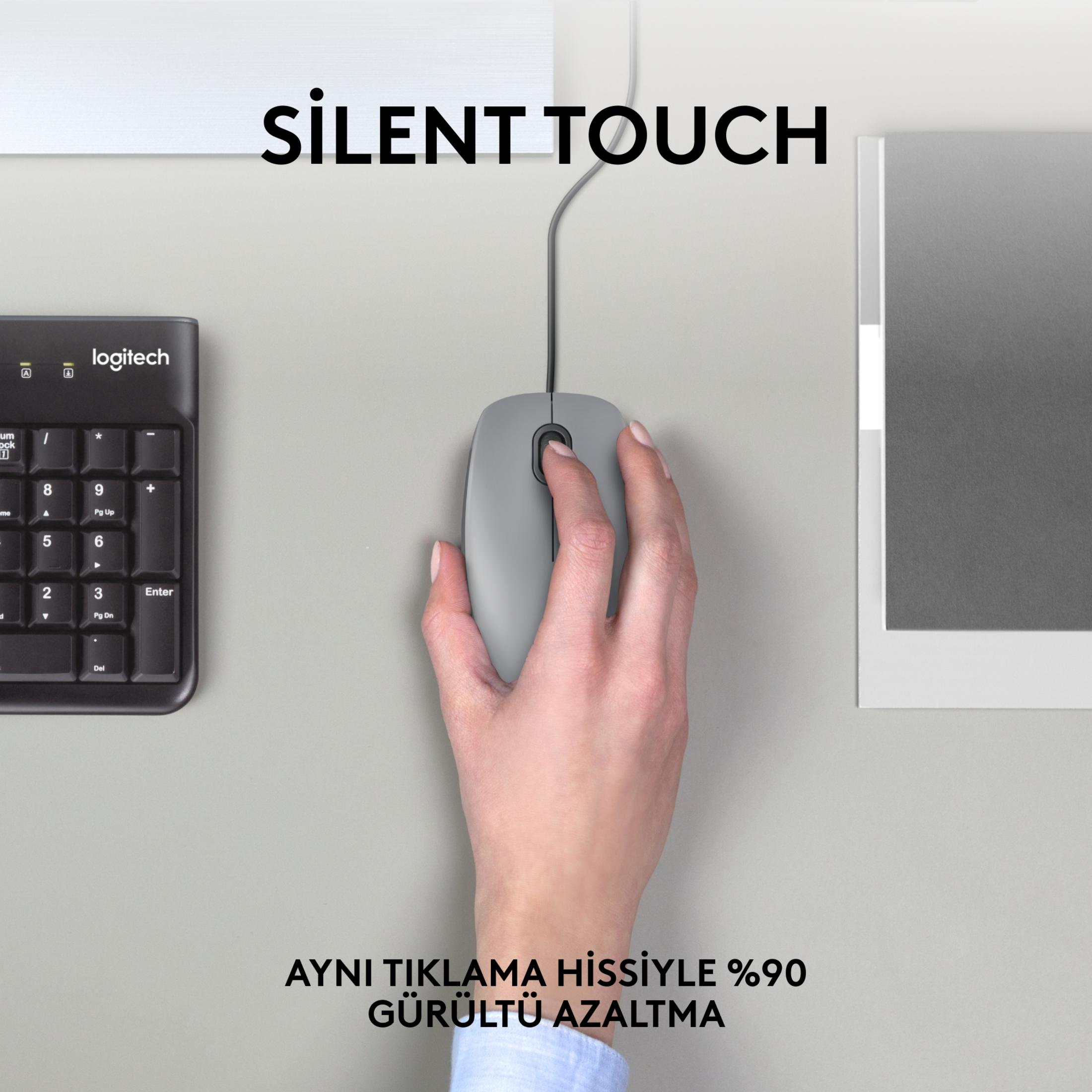 Dłoń obsługuje szary mysz obok klawiatury Logitech.