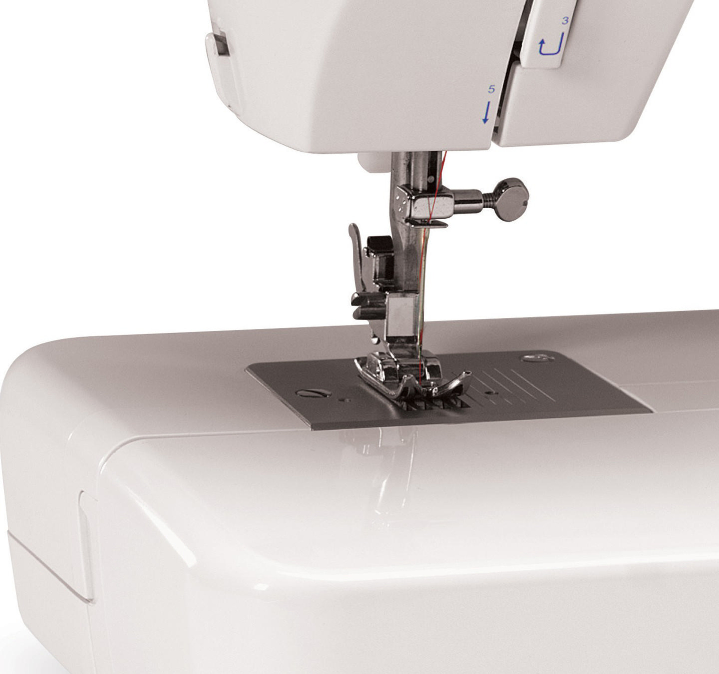 Zbliżenie białej maszyny do szycia z igłą i czerwoną nicią.
