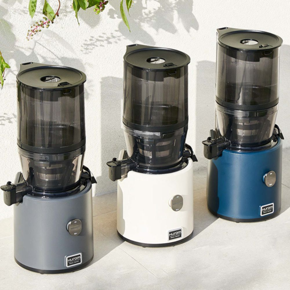 Drei Slow-Juicer in Grau, Weiß und Blau stehen nebeneinander.