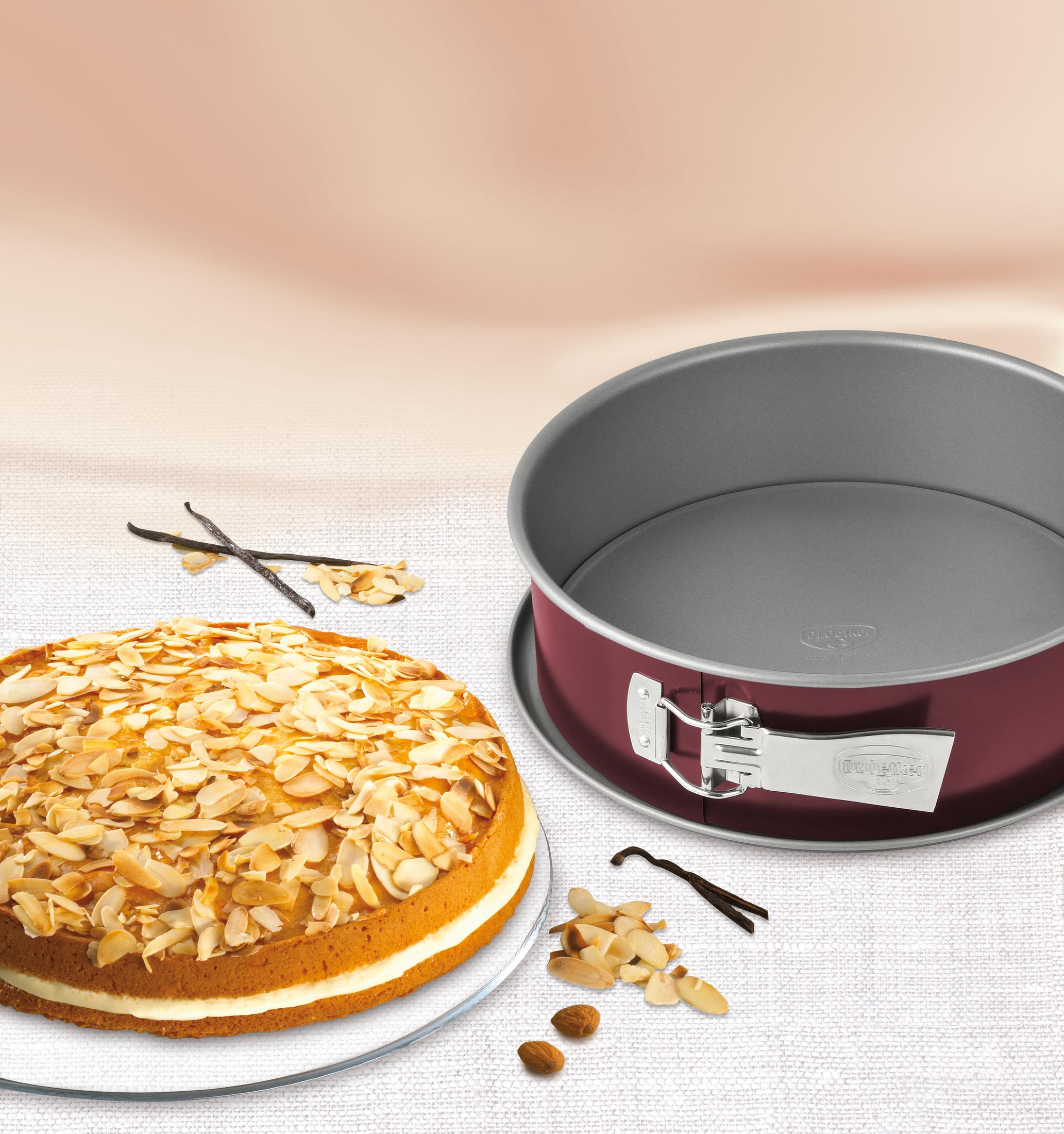 Ein Kuchen mit Mandelsplittern und eine rote Springform mit Vanilleschoten.