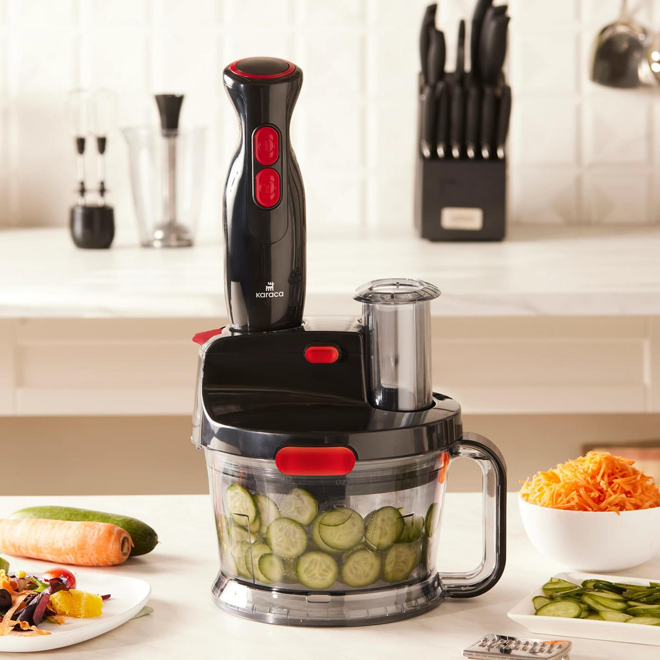 Dilimlenmiş salatalıklı mutfak robotu doğrayıcısı üzerinde siyah el blender aparatı.