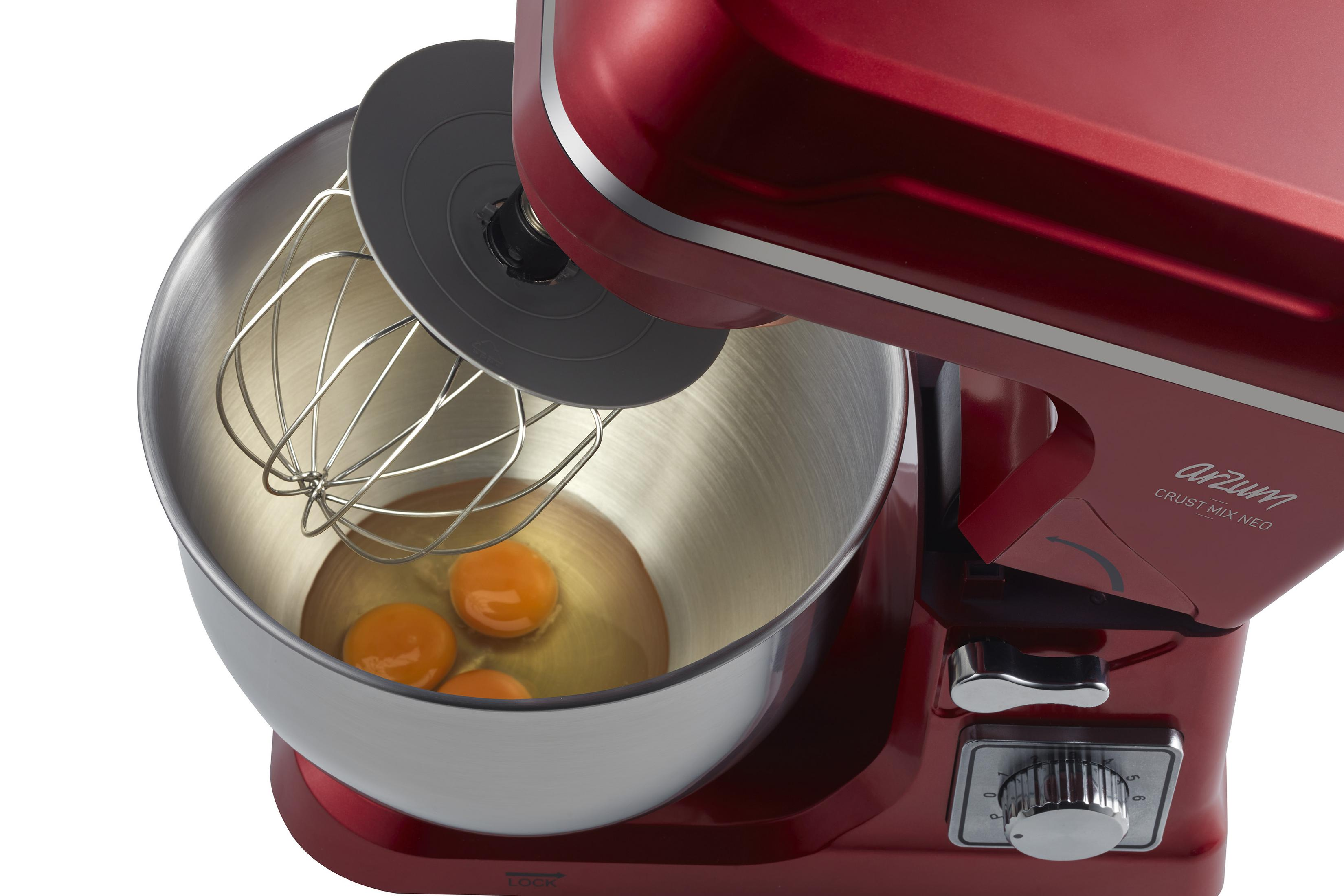 Roter Küchenmixer mit Schneebesen und drei Eiern in einer Edelstahlschüssel.