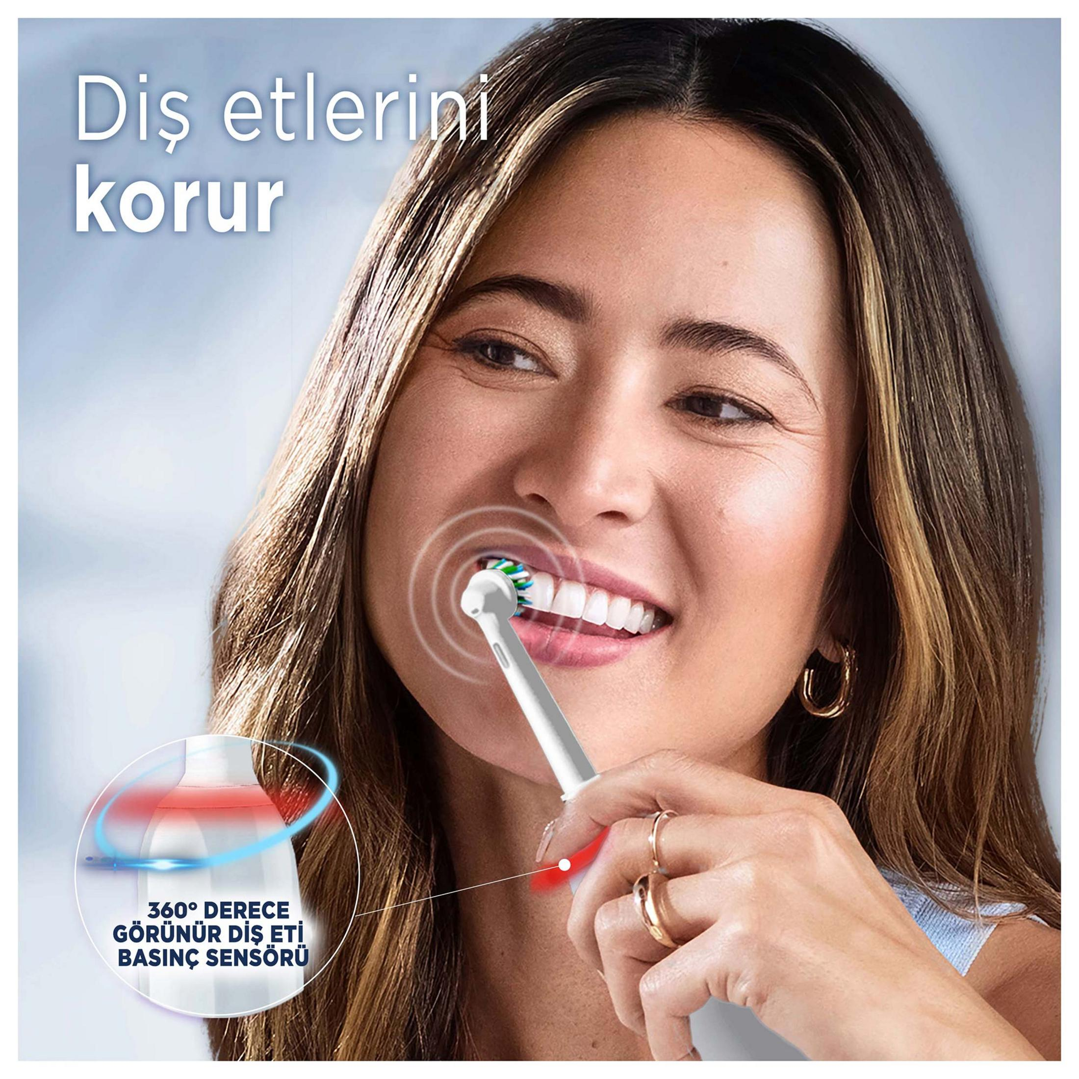 Una mujer se cepilla los dientes con un cepillo eléctrico con sensor de presión.