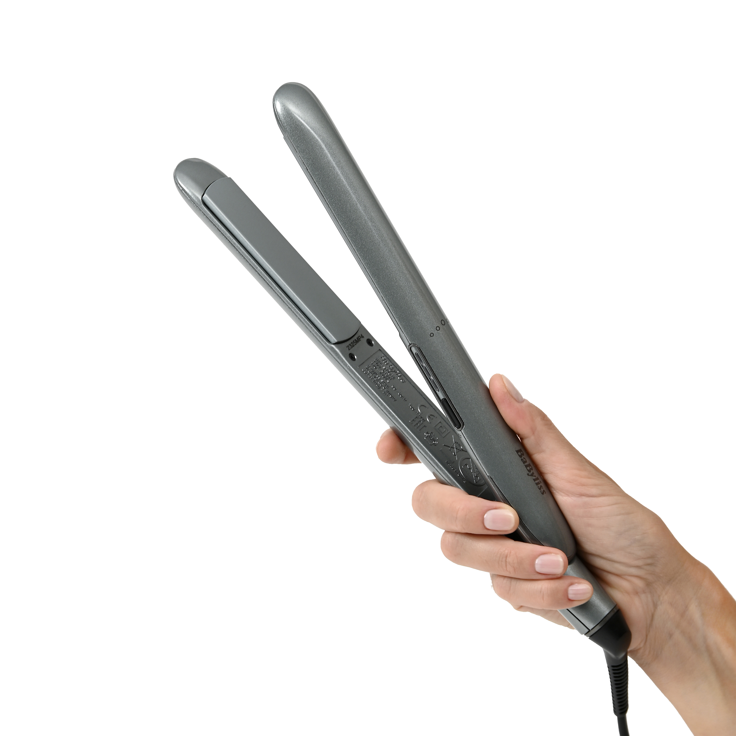 A hand holds a gray hair straightener with a cord.