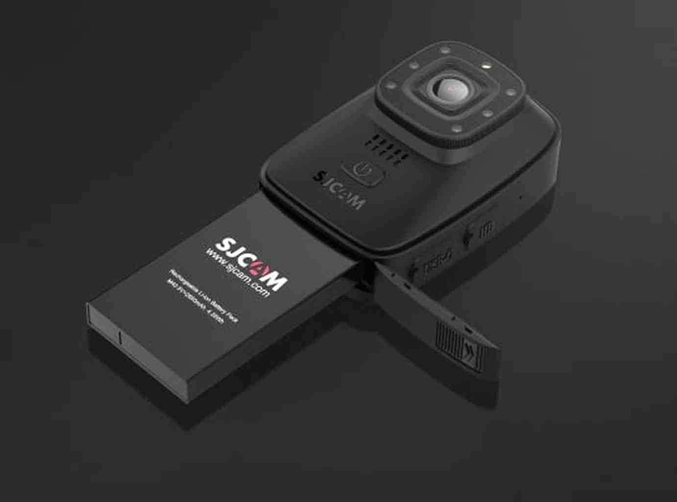 Compatta fotocamera SJCAM nera con batteria estesa su sfondo scuro.
