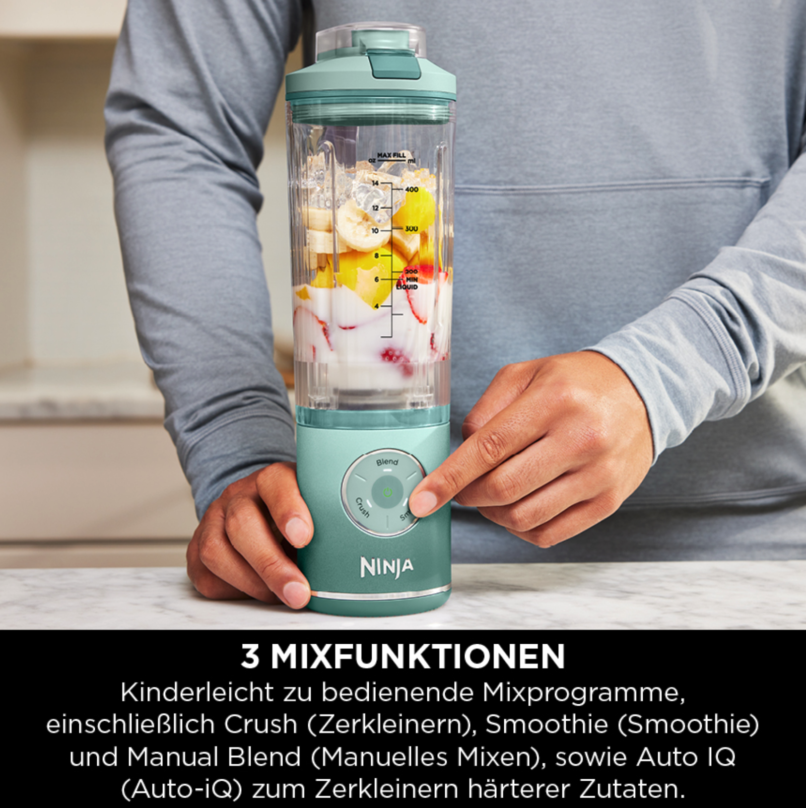 Un uomo tiene un frullatore con frutta e ghiaccio. Preme un pulsante.