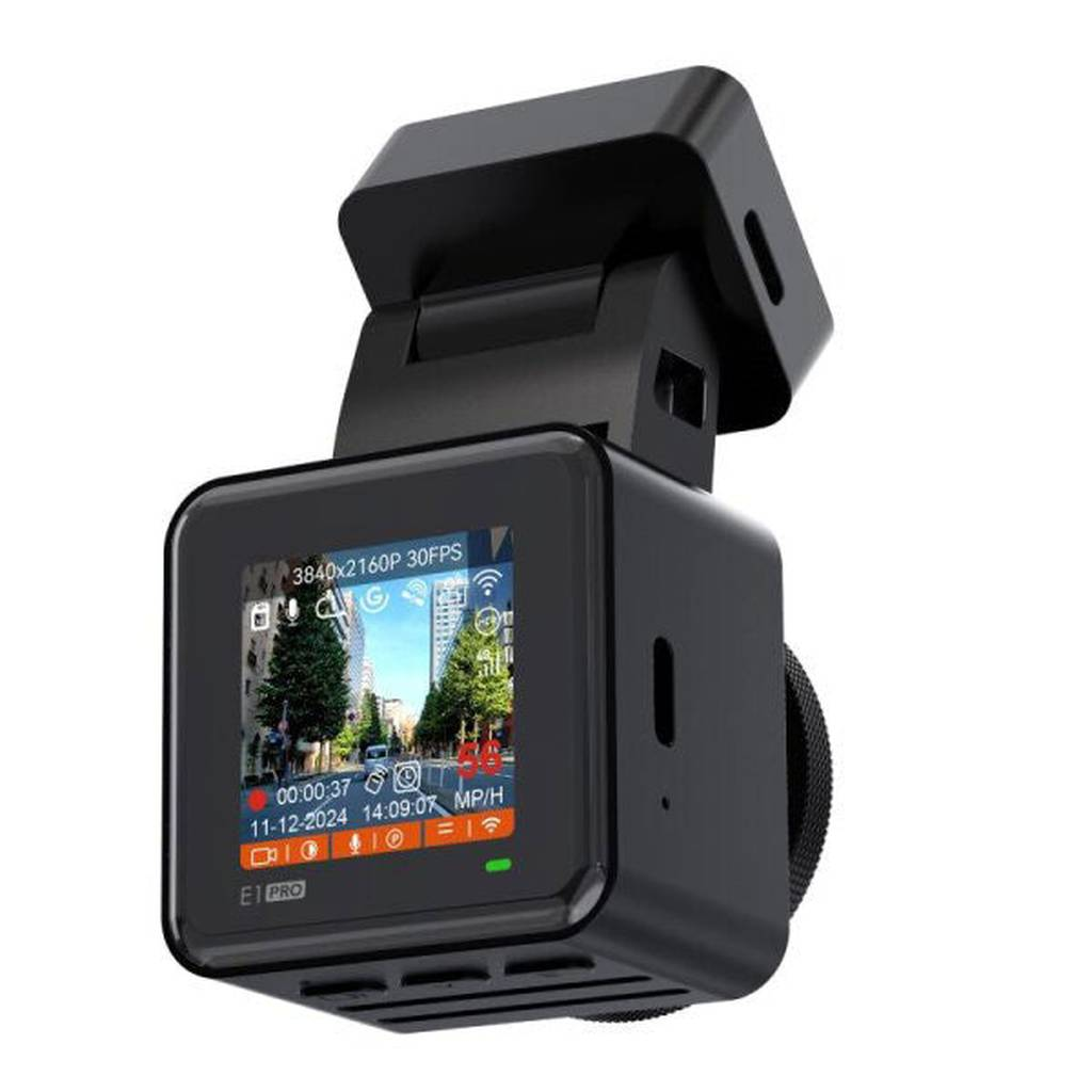 Black dashcam screen shows a street with trees, cars, and buildings.