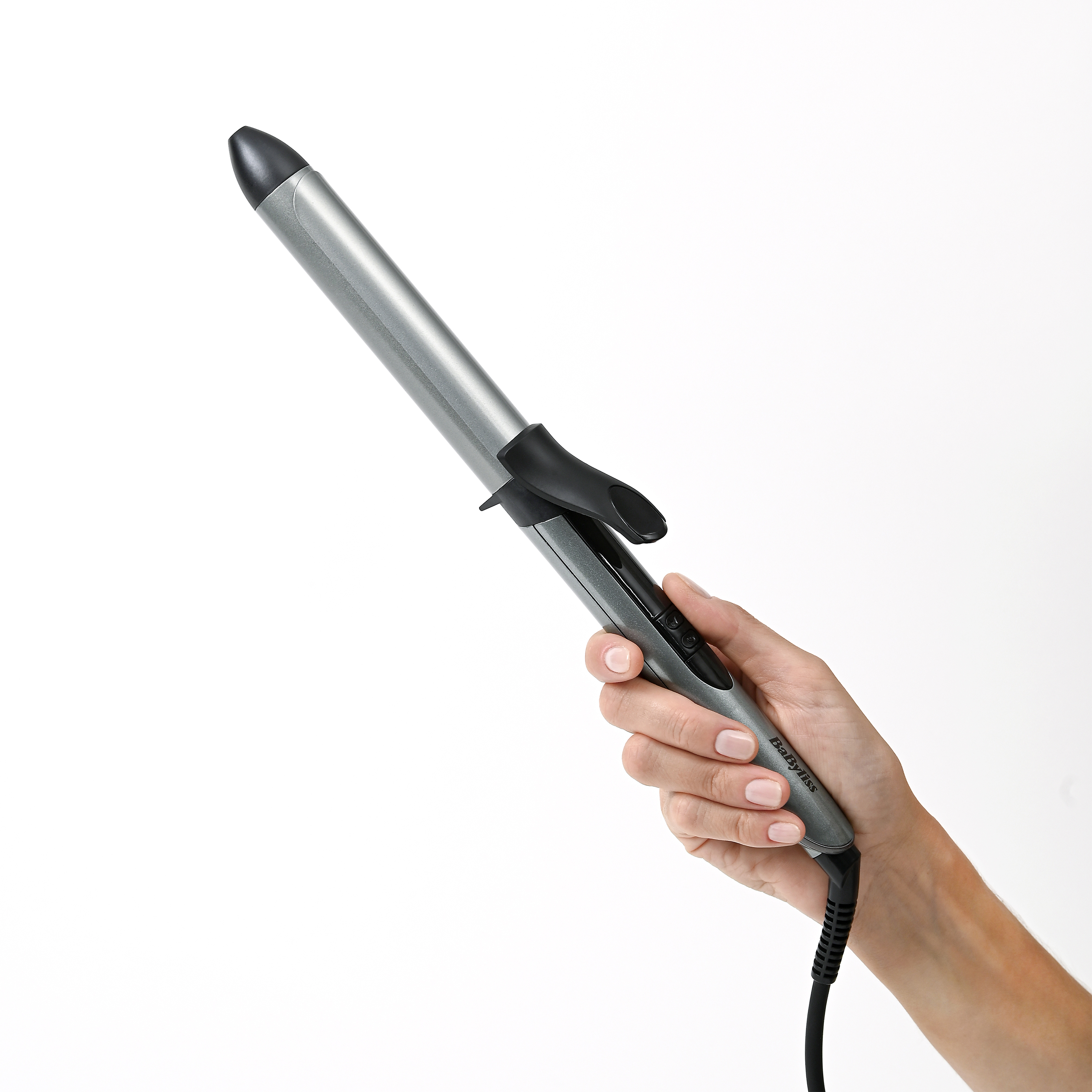 Een hand houdt een zilveren krultang vast met zwarte handgreep en snoer.