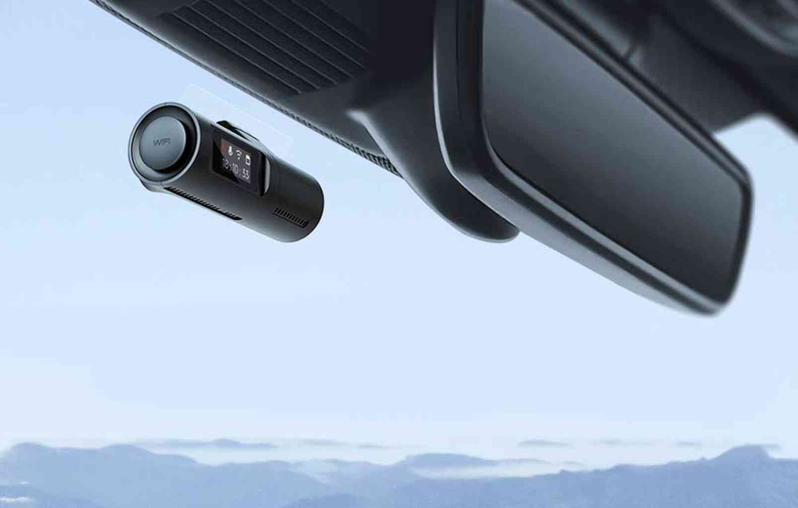 Autocamera met WiFi-symbool en display, bevestigd aan de achteruitkijkspiegel.