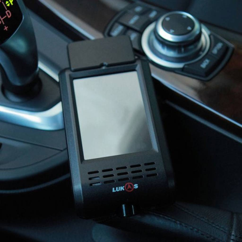 Een zwart navigatieapparaat met scherm en ventilatieopeningen in een auto.