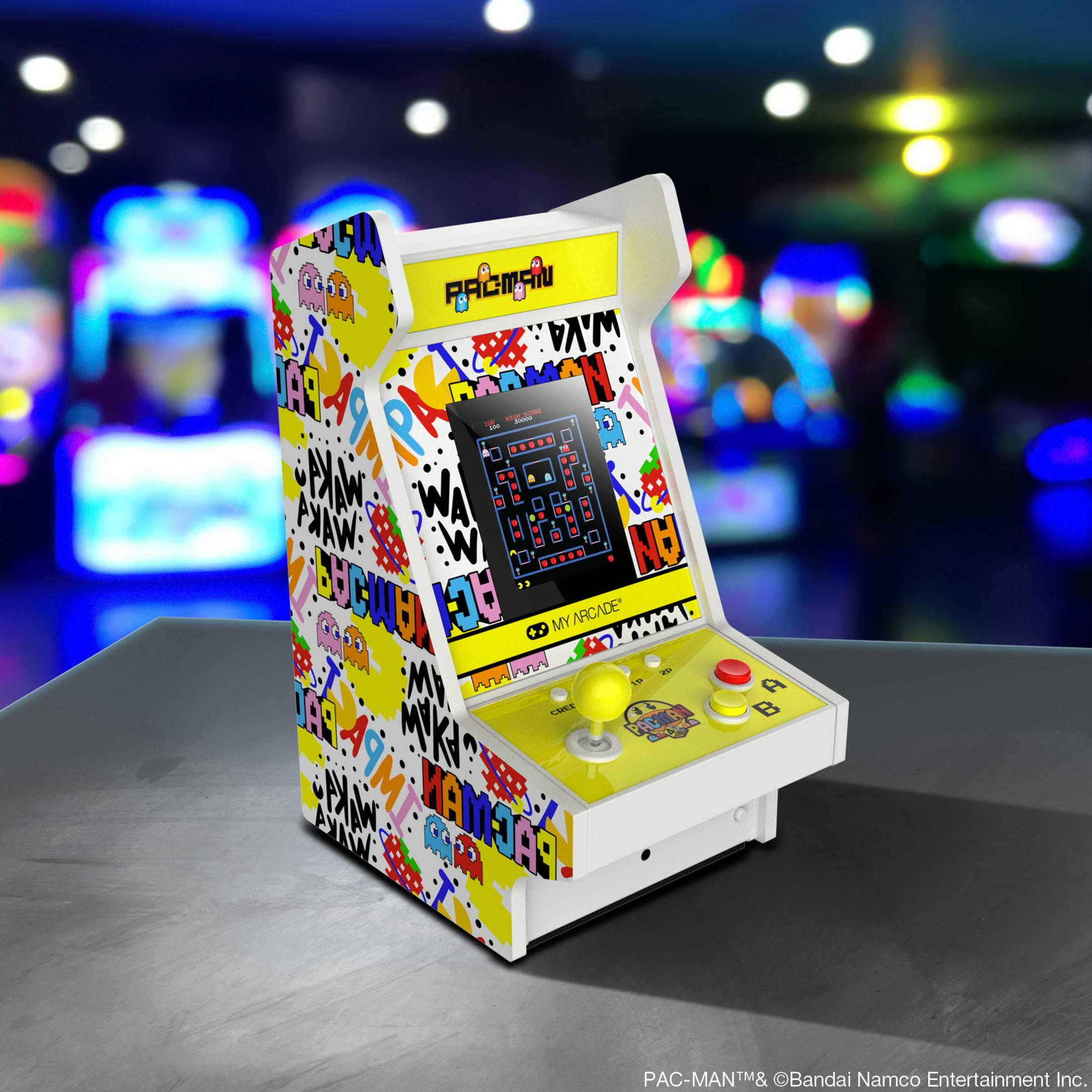 Una macchina arcade Pac-Man con esterno colorato e schermo di gioco.