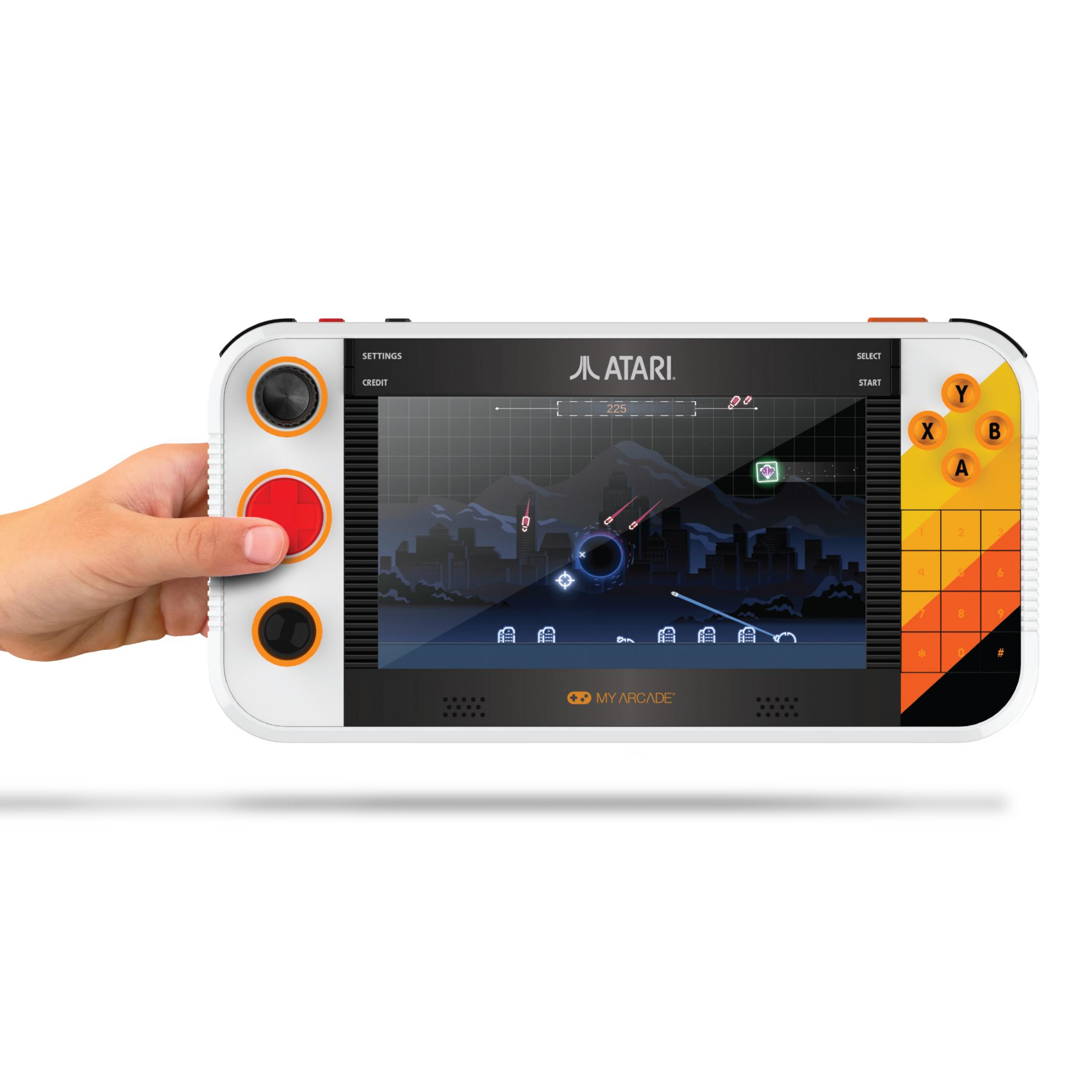 Una mano tiene una console portatile Atari bianca con uno schermo che mostra un gioco sparatutto spaziale.