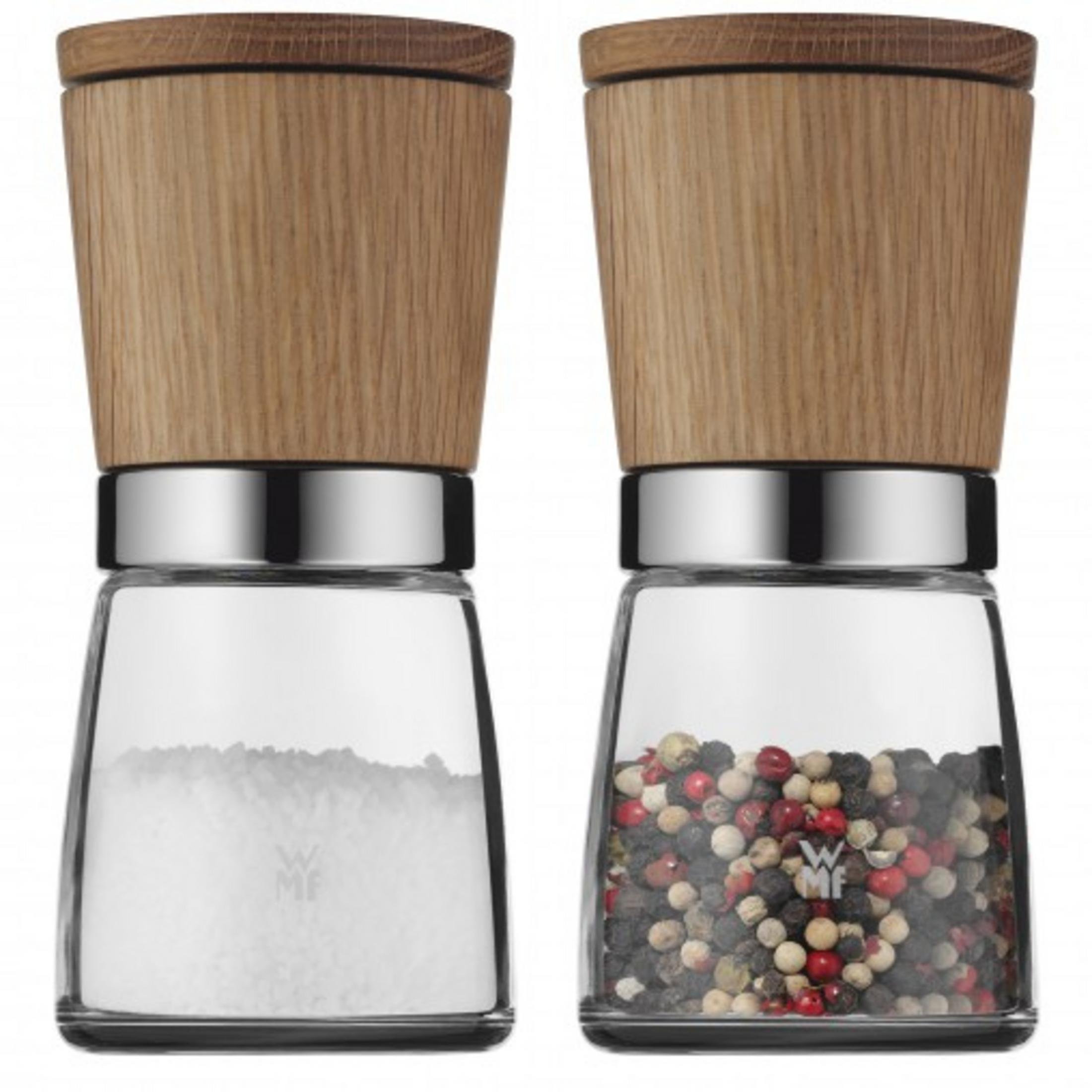 Zwei Gewürzmühlen aus Glas mit Holzdeckel, eine gefüllt mit Salz, die andere mit Pfefferkörnern.