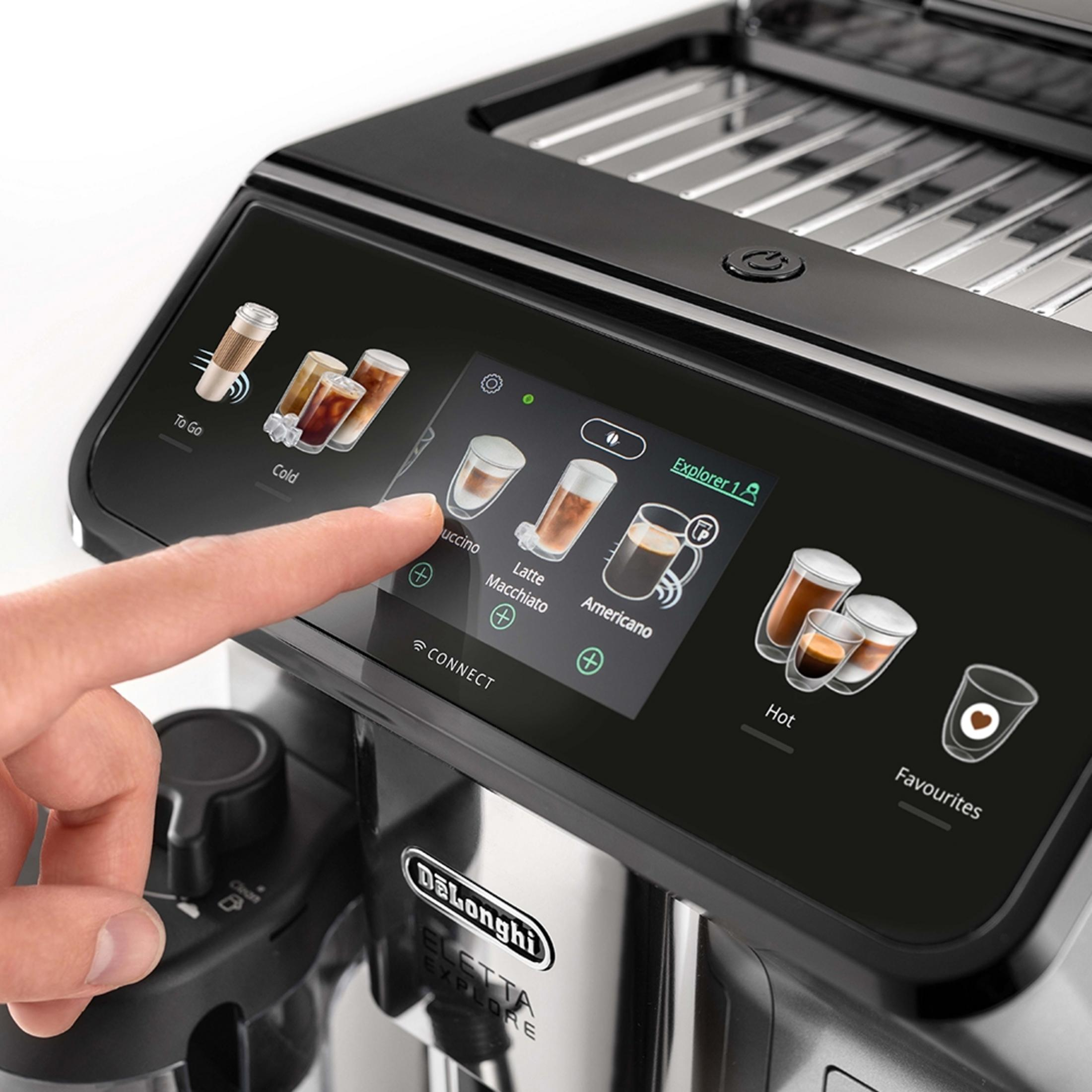 Un dito tocca il touchscreen di una macchina da caffè che mostra varie bevande.
