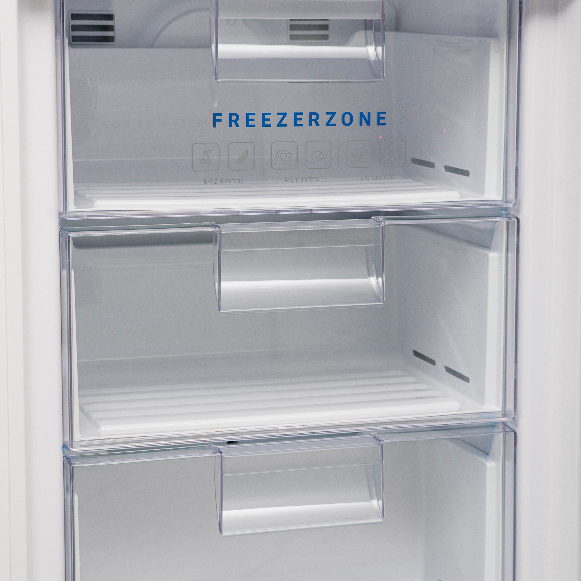 Drei transparente Gefrierschubladen mit Symbolen für Obst, Gemüse, Käse und Fleisch.