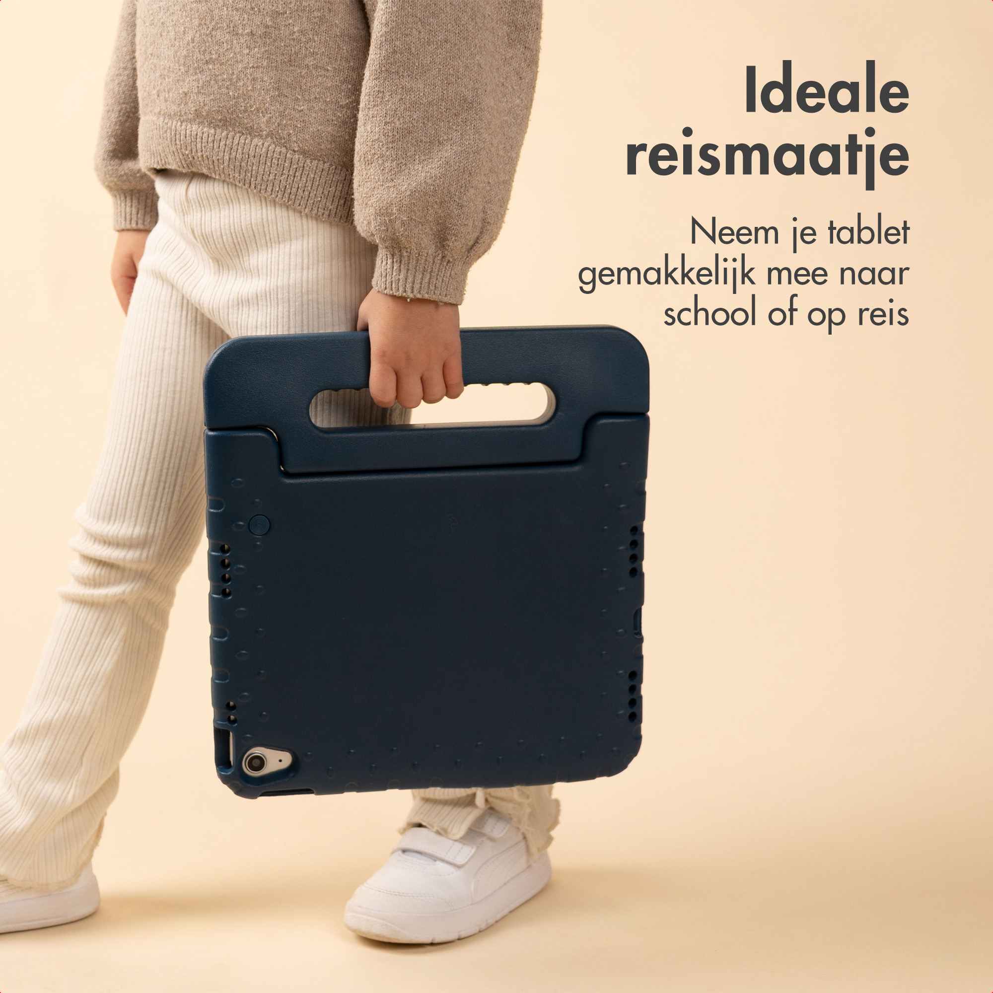 Kind met donkerblauwe tablethoes, beige broek en trui.