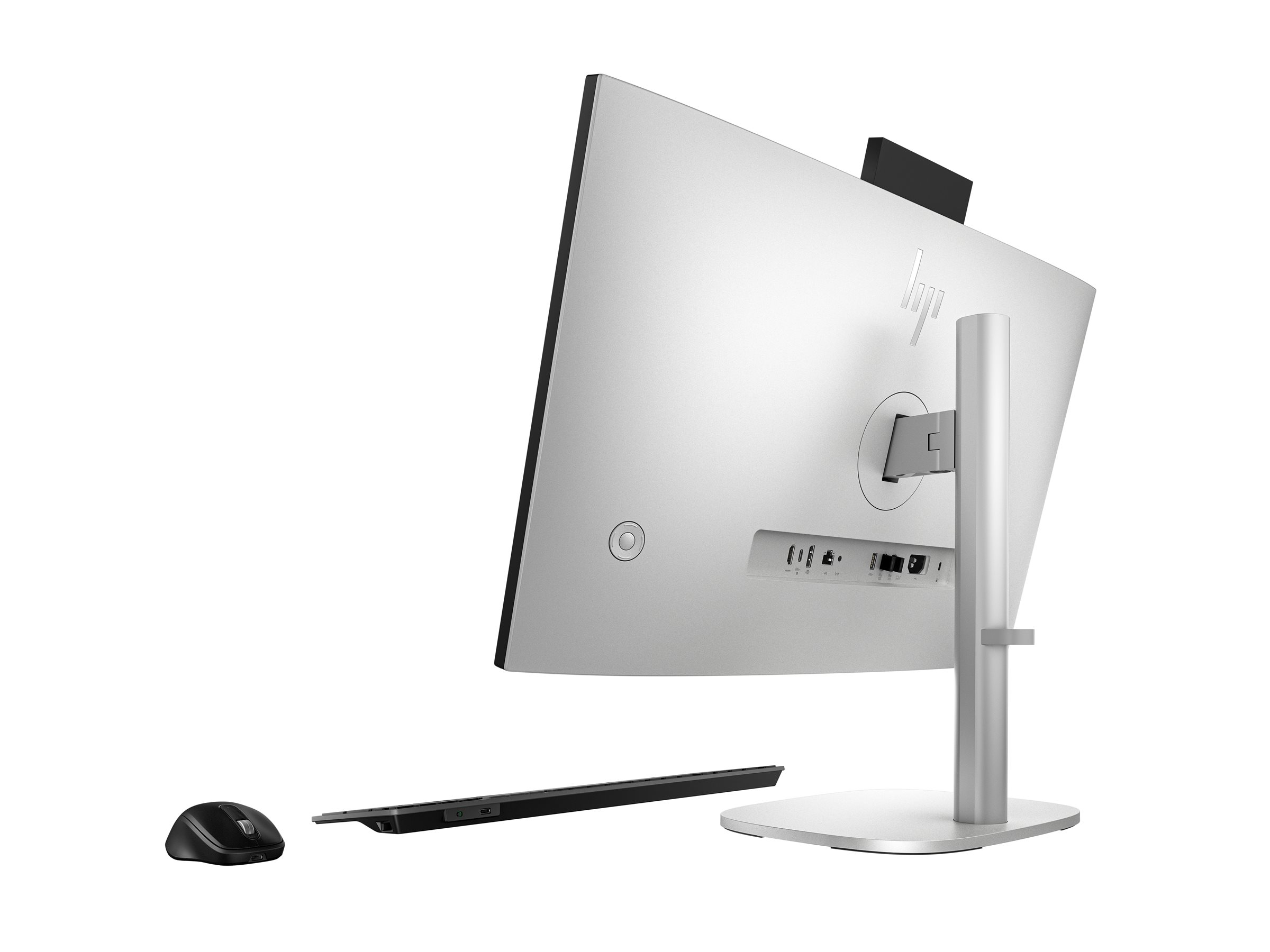 Srebrny komputer All-in-One HP, widok od tyłu z portami, myszką i klawiaturą.