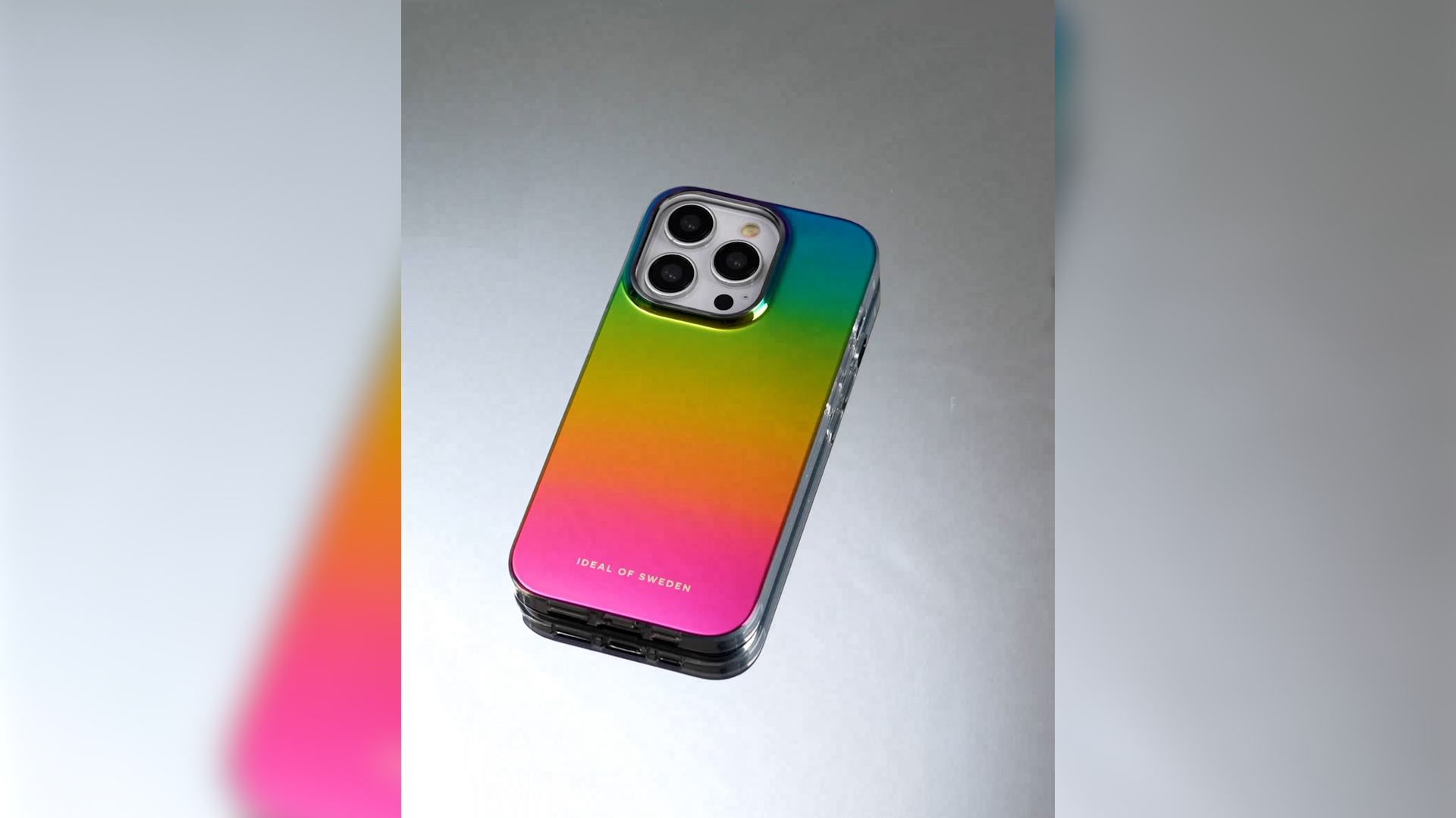 Ein iPhone mit einem bunten Farbverlauf von Grün bis Pink auf glatter Oberfläche.