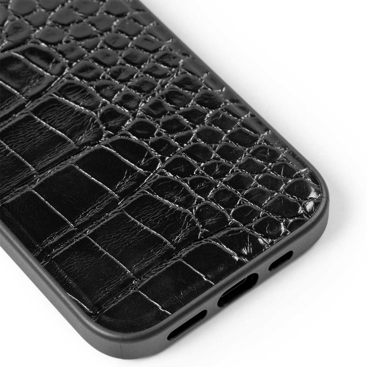 Schwarze Handyhülle mit krokodilartiger Textur und Ausschnitten.