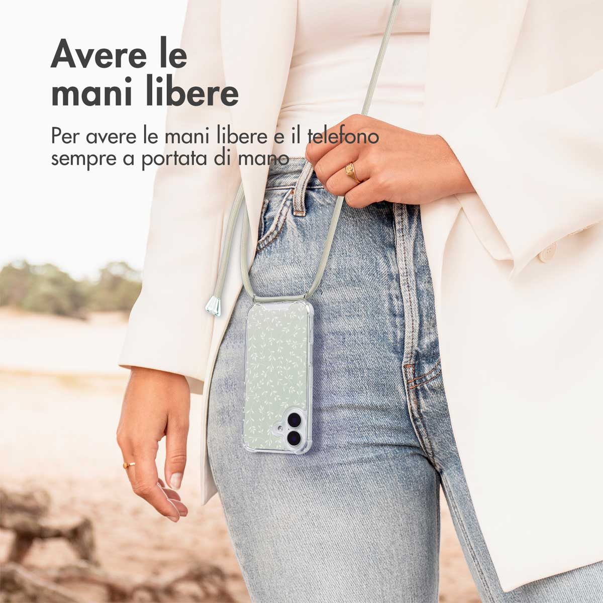 Een vrouw draagt een spijkerbroek en wit jasje met een telefoonhoesje aan een koord.