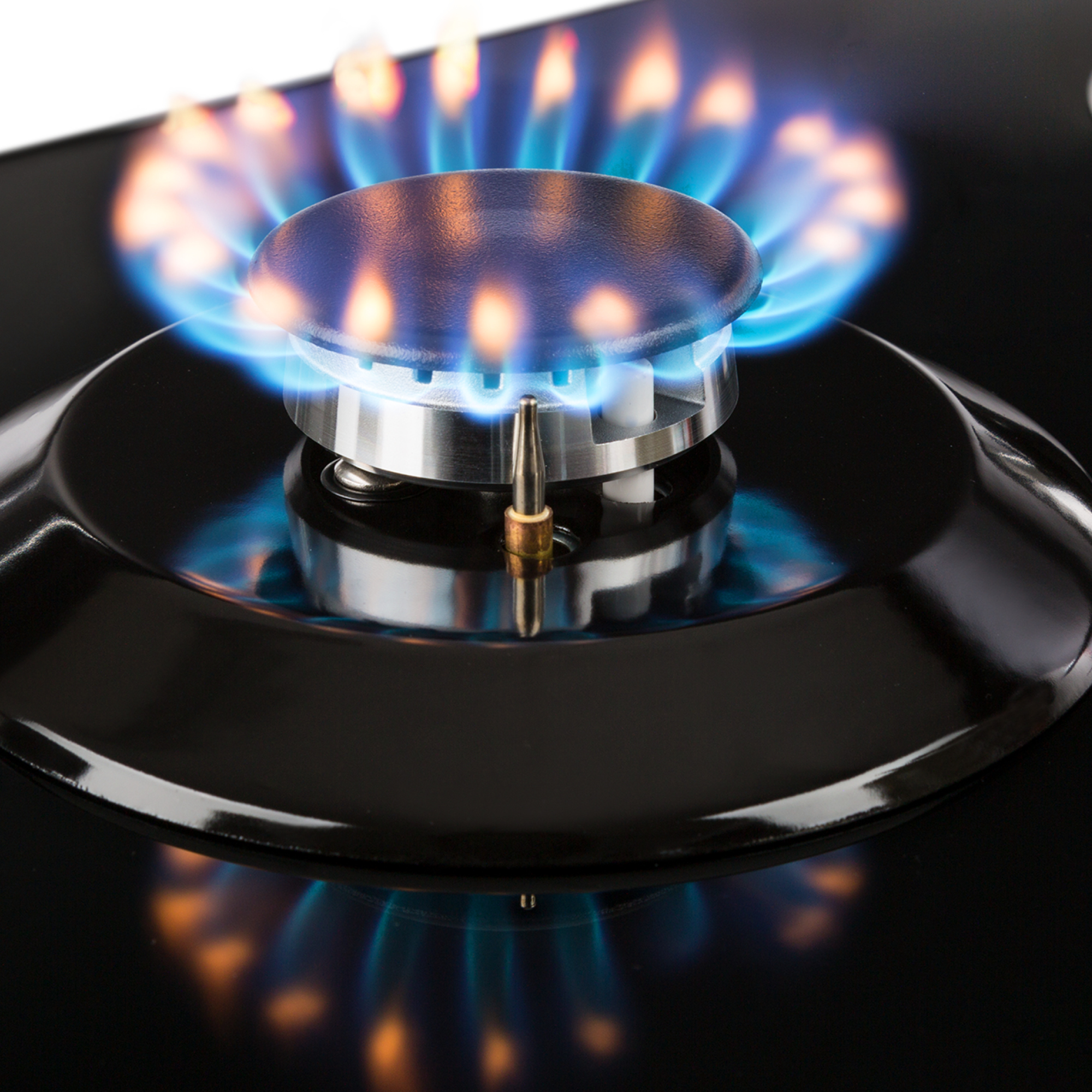 Un bruciatore a gas su un piano cottura nero con fiamma blu.