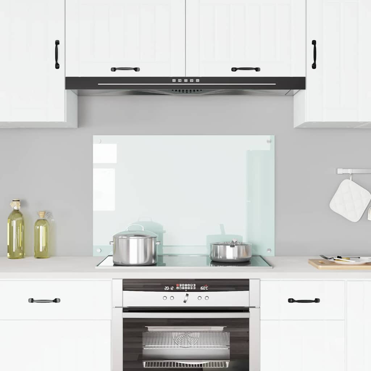 Cocina moderna con gabinetes blancos, vitrocerámica y campana de acero.