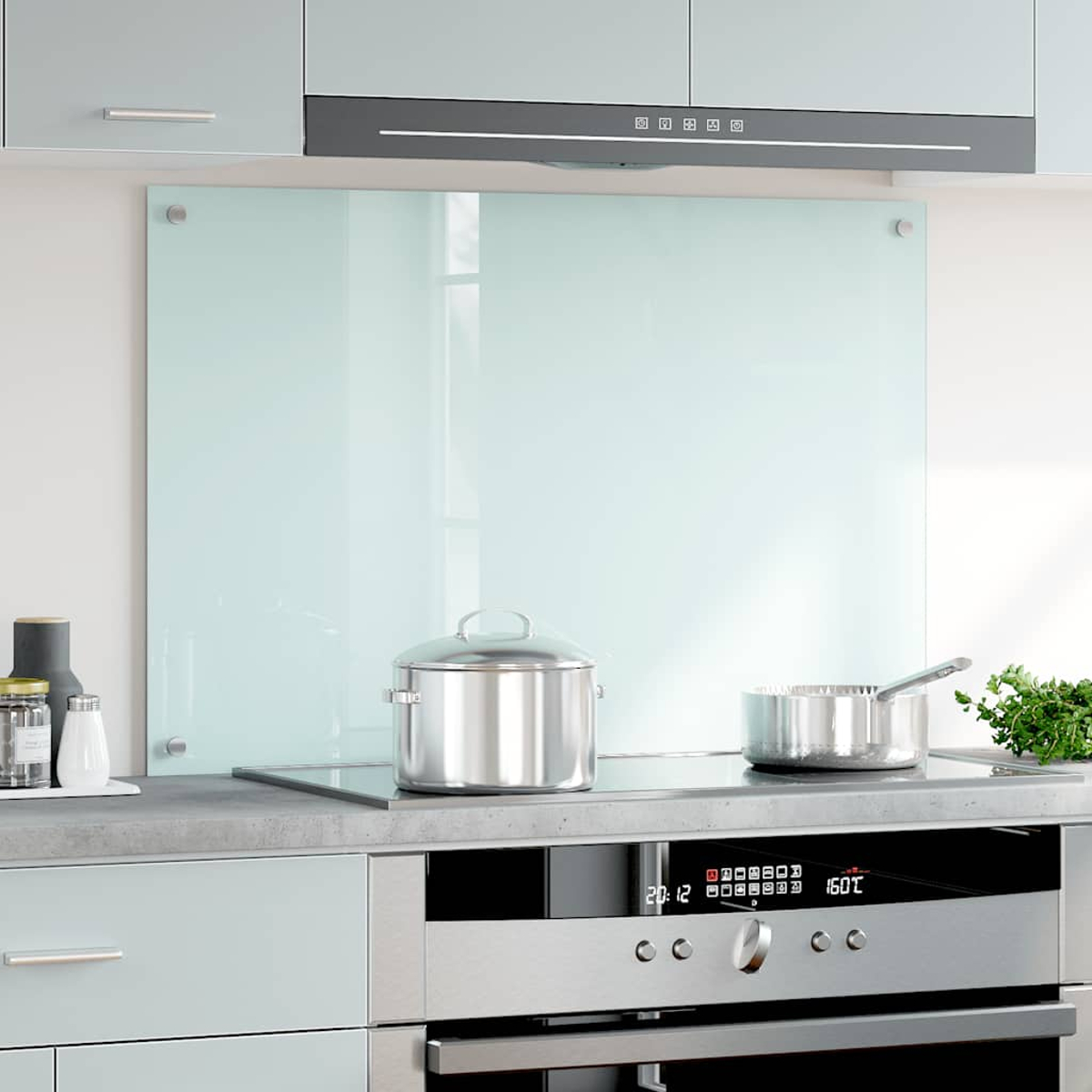 Cocina moderna con salpicadero de cristal, ollas en la estufa y campana extractora.