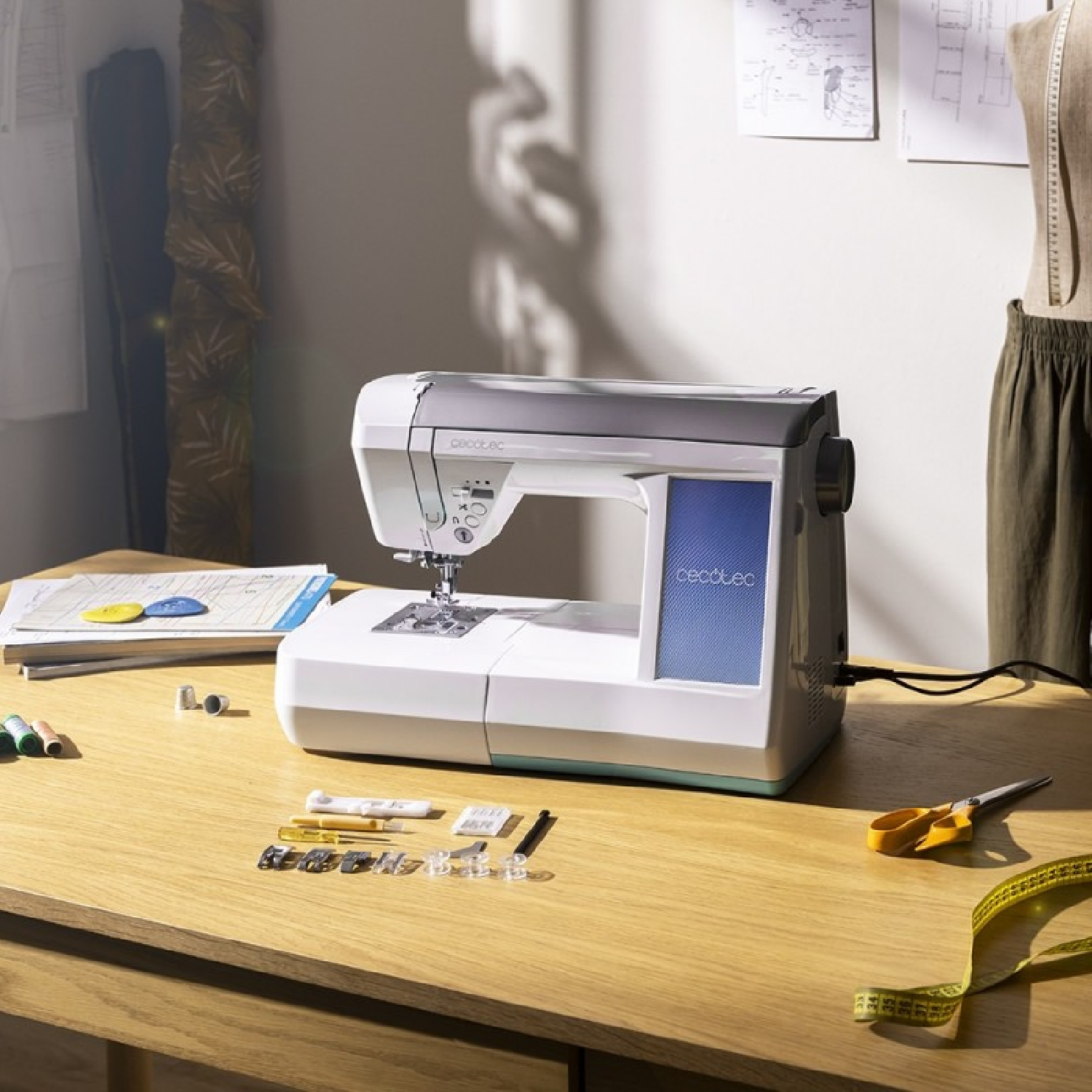 Una máquina de coser sobre una mesa de madera con accesorios como hilo, agujas y tijeras.