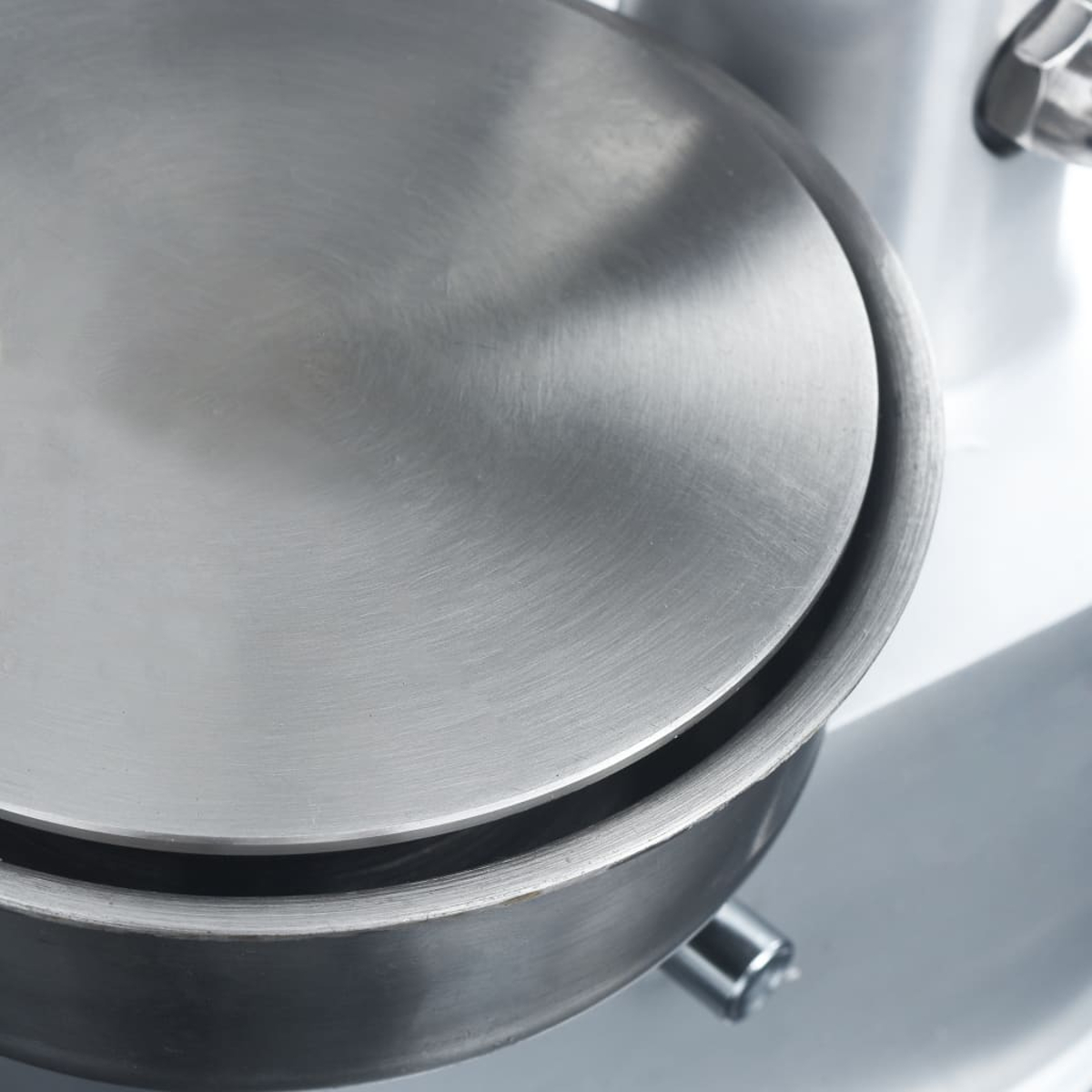 Detailaufnahme einer Metallschale mit einem runden Deckel, die Teil einer Maschine ist.