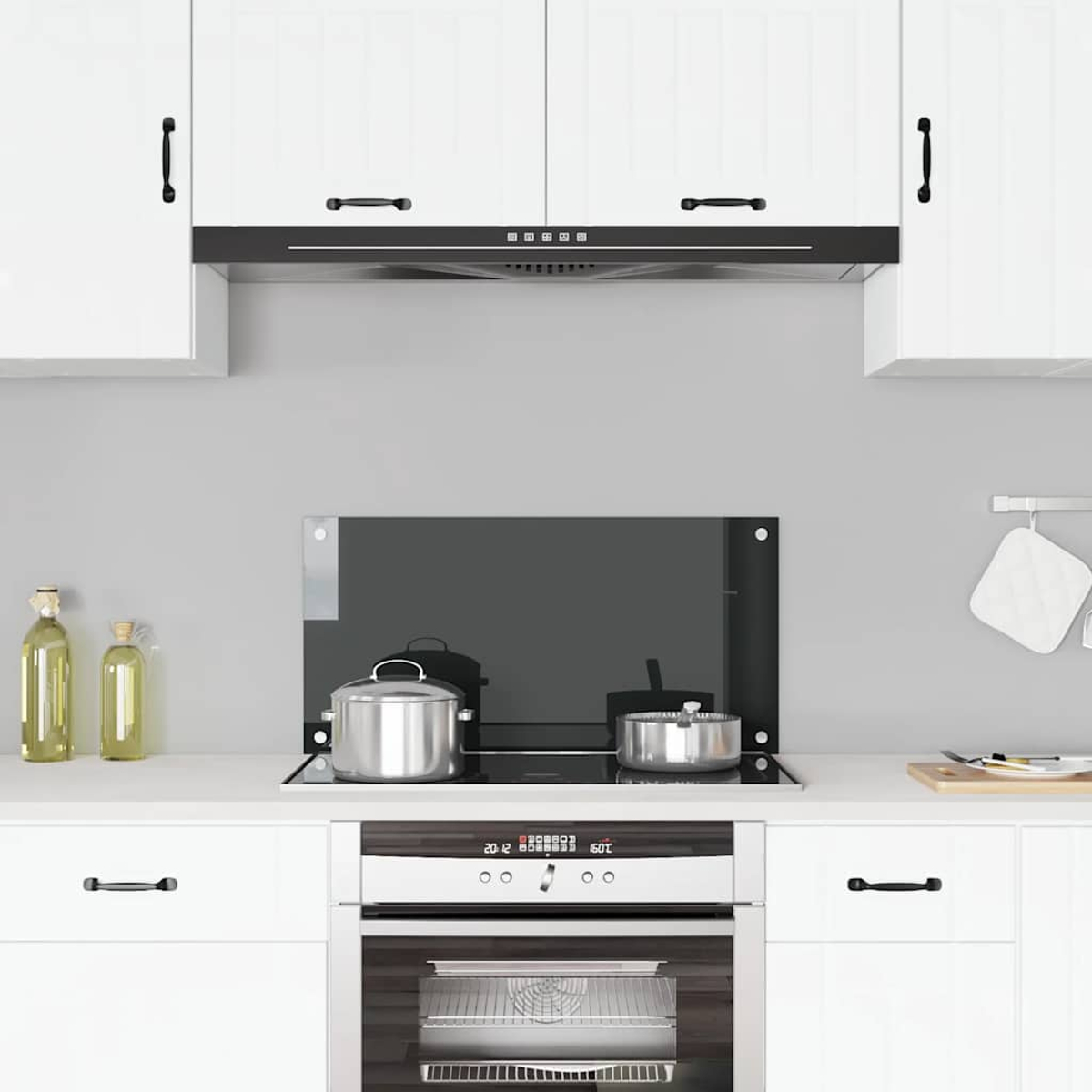 Cocina moderna con gabinetes blancos, campana extractora y vitrocerámica.