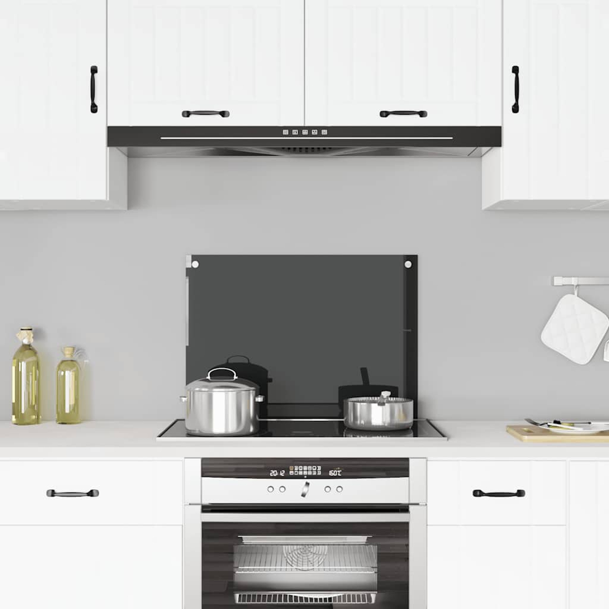 Cocina moderna con gabinetes blancos, estufa con ollas y horno.