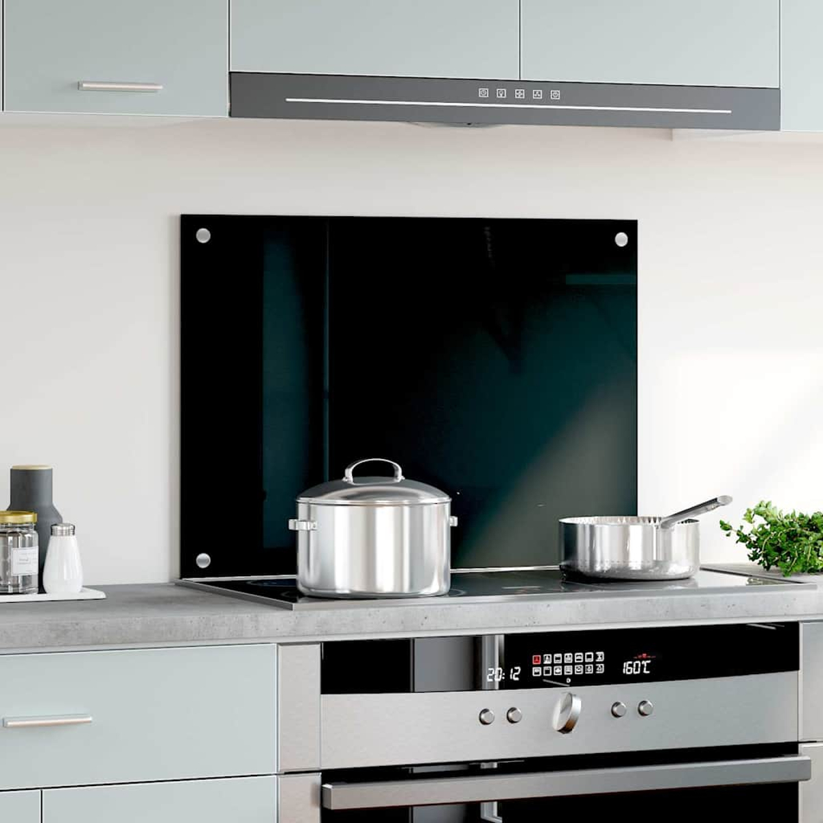 Una cocina moderna con vitrocerámica, ollas y salpicadero de cristal negro.